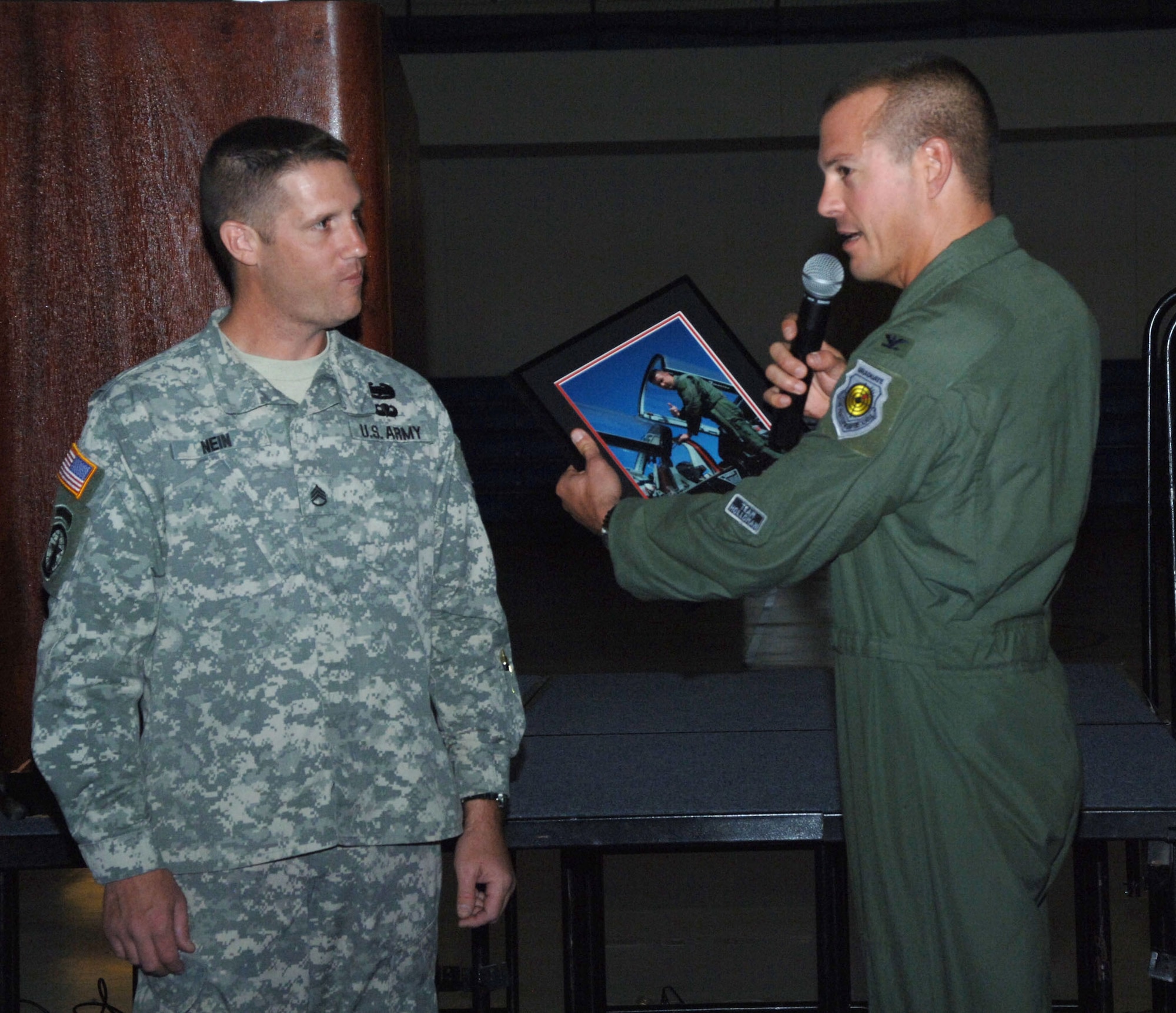 Army Staff Sgt. Timothy Nein is given a photo of his T-38 ride from Col. Michael McGee, 49th Fighter Wing vice commander, during a Warrior Call Oct. 19. The Warrior Call featured two heroes, Tech. Sgt. William Wilson, a sensor operator on AC-130Us from Hurlbert Field, Fla., and Army Staff Sgt. Timothy Nein, a military police with the 223rd Military Police Company with the Louisville, Ky., National Guard. (U.S. Air Force photo/Airman 1st Class Tiffany Trojca)