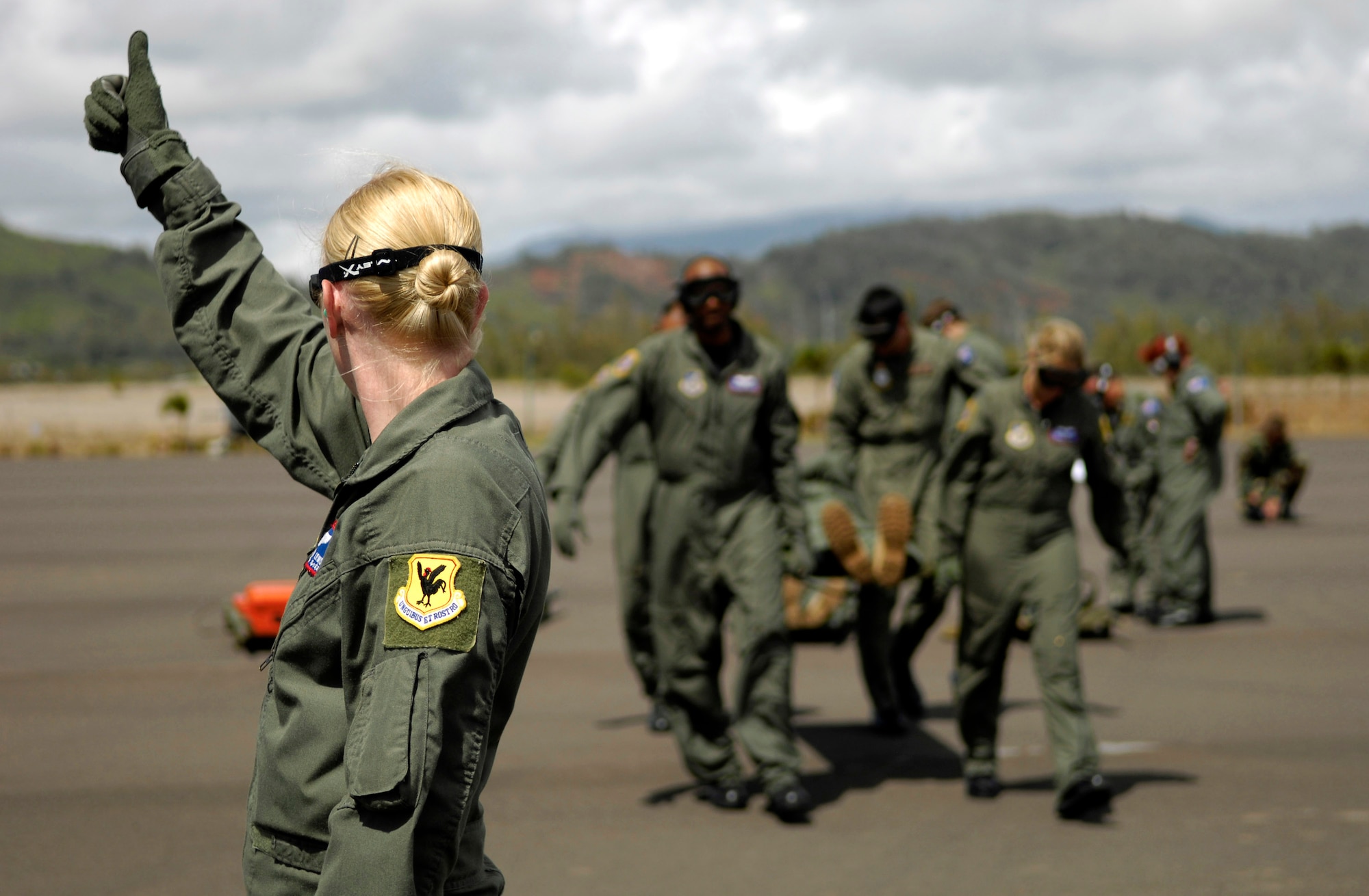 Staff Sgt. Kristen Lewis signals a crew of Air Force and Royal Australian Air Force medical personnel to load a patient on to a C-17 Globemaster III Oct. 16 during aeromedical evacuation operations training at Kona International Airport, Hawaii. Airmen from the 18th Aeromedical Squadron from Kadena Air Base, Japan, are there to train RAAF medical personnel who will be using specialized equipment and the C-17 for aeromedical evacuation. Sergeant Lewis is with the 18th AMS.  (U.S. Air Force photo/Tech. Sgt. Shane A. Cuomo) 