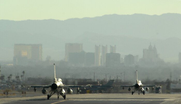 With the world famous Las Vegas Strip as the backdrop, two F-16 Fighting Falcons taxi out Oct. 18, 2007 at Nellis Air Force Base, Nev. The F-16’s are assigned to the 63rd Fighter Squadron, “The Panthers,” Luke AFB, Ariz. The 63rd FS is at Nellis supporting F-15 Eagles with the U.S Air Force Weapons School in an adversary tactics role.  (Air Force photo by Master Sgt. Kevin J. Gruenwald)


