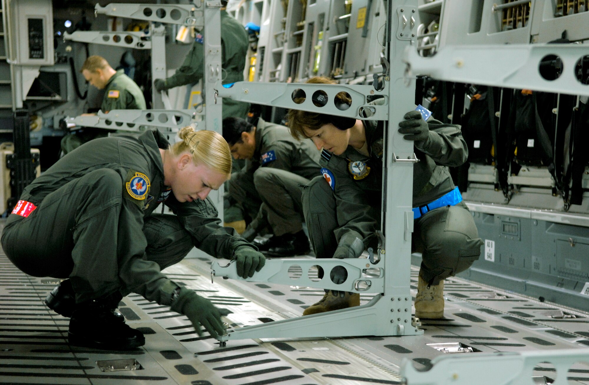 Staff Sgt. Kristen Lewis (left) and Royal Australian Air Force Flight Lt. Michelle Cole set up litter racks on a C-17 Globemaster III during aeromedical evacuation operations training Oct. 17 at Hickam Air Force Base, Hawaii. Airmen from the 18th Aeromedical Squadron at Kadena Air Base, Japan, are at Hickam to train RAAF medical personnel who will be using specialized equipment and the C-17 for aeromedical evacuation.  Sergeant Lewis is with the 18th AMS.  (U.S. Air Force photo/Tech. Sgt. Shane A. Cuomo) 