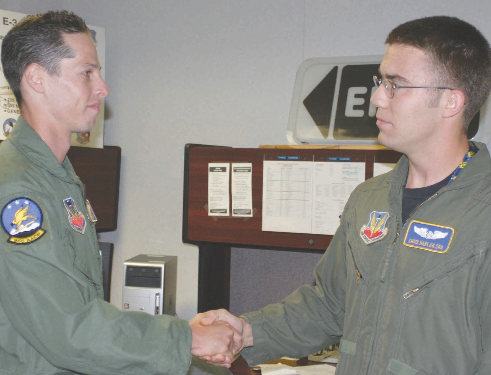 Senior Airman Chris Harlan, right, is congratulated by one of his supervisors, Staff Sgt. Jason Malin, for his heroic act. (Air Force photo by 2nd Lt. Kinder Blacke)