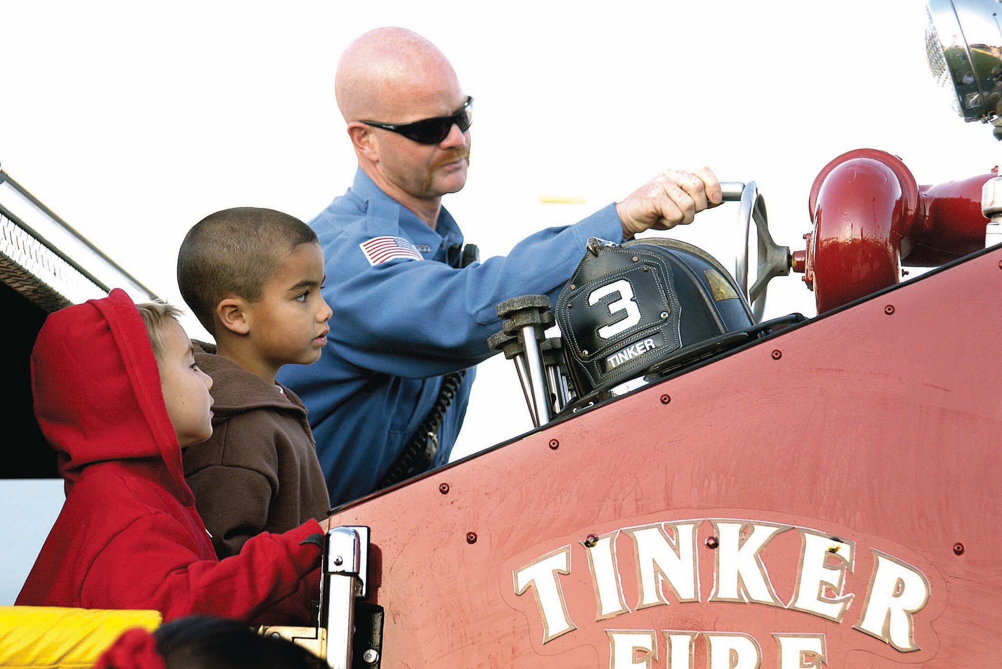 Outside the Child Development Center East, children like Andrew Hobbs and Carson Cram gravitate to the large fire truck where Tinker firefighters wait to give kids the tour. Both on-base daycare facilities were visited as part of Fire Prevention Week activities Oct. 6-12. (Air Force photo by Margo Wright)