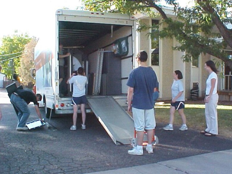 Members of the 21st Operations Support Squadron's intelligence flight help unload trucks full of office furniture Oct. 5. The Airmen moved furniture for a local nonprofit as part of Make a Difference Day.  (Courtesy photo)
