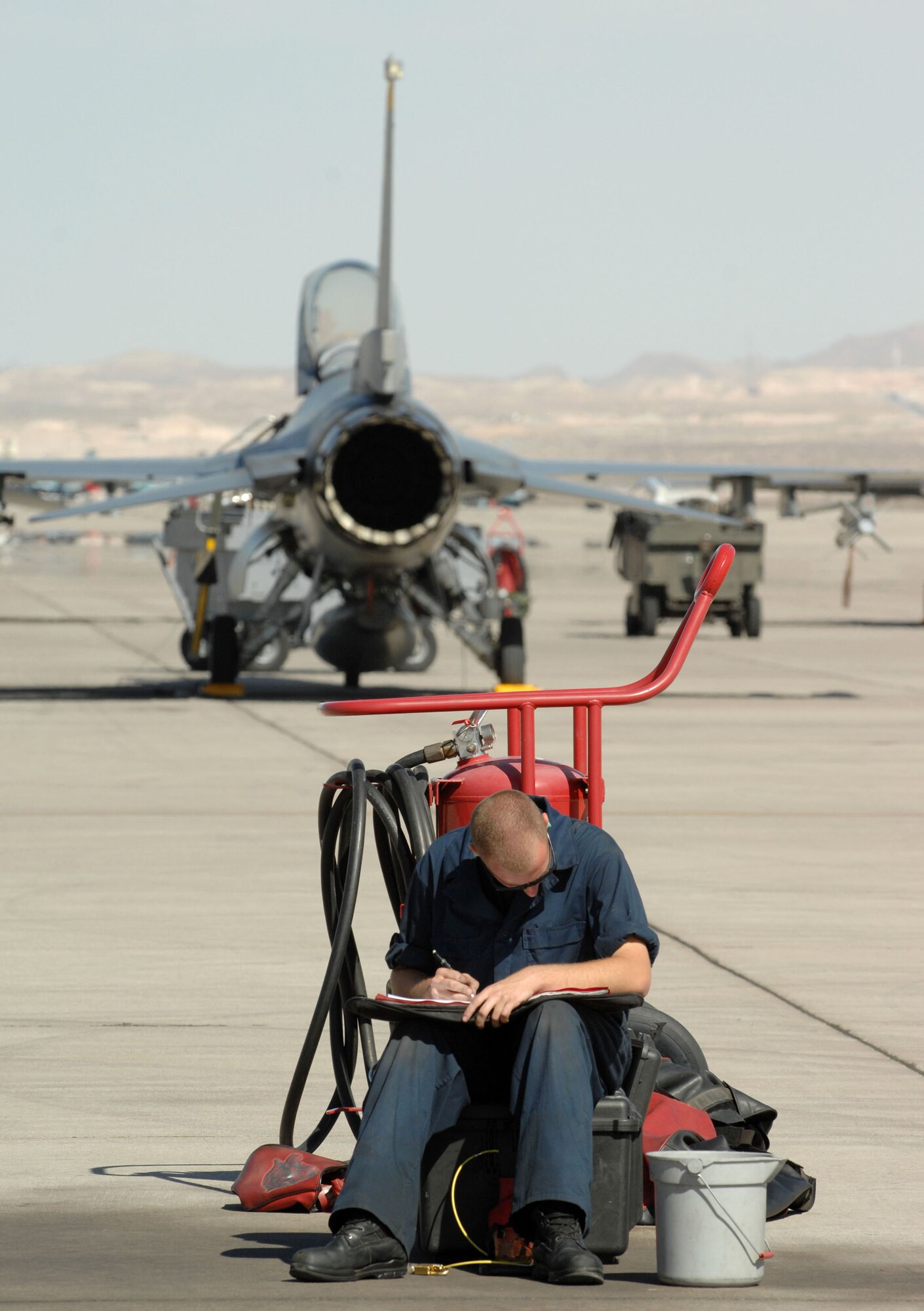 Airman 1st Class Andrew Davis reviews F-16 Fighting Falcon post flight inspection forms Oct. 18 at Nellis Air Force Base, Nev. Airman Davis is a 63rd Fighter Squadron crew chief from Luke AFB, Ariz. The 63rd FS is at Nellis AFB supporting the F-15 Eagle Weapons School Instructor Course in an adversary tactics role. (U.S. Air Force photo/Master Sgt. Kevin J. Gruenwald) 

