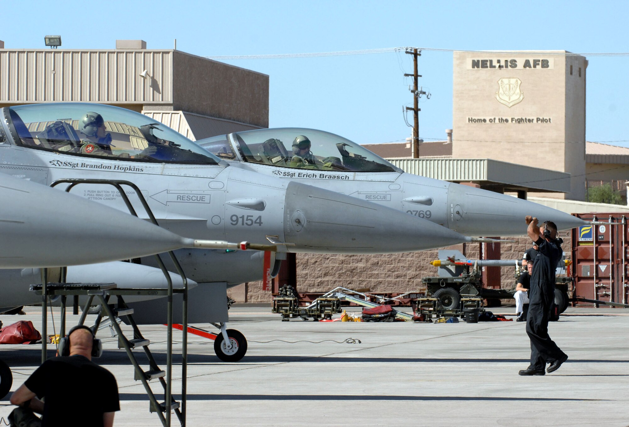 Senior Airman Jovany Ruvalcaba marshals in an F-16 Fighting Falcon Oct. 18 at Nellis Air Force Base, Nev. Airman Ruvalcaba is a 63rd Fighter Squadron crew chief from Luke AFB, Ariz. The 63rd FS is at Nellis AFB supporting the F-15 Eagle Weapons School Instructor Course in an adversary tactics role. (U.S. Air Force photo/Master Sgt. Kevin J. Gruenwald) 
