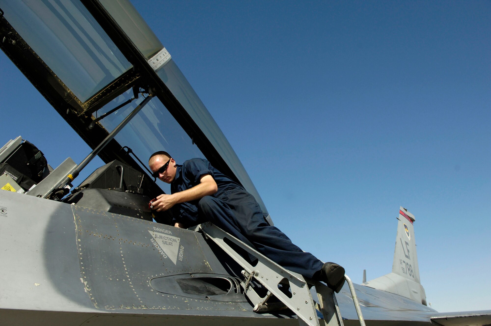 Airman 1st Class Andrew Davis performs an F-16 Fighting Falcon through-flight inspection in between launches Oct. 18 at Nellis Air Force Base, Nev. Airman Davis is a 63rd Fighter Squadron crew chief from Luke AFB, Ariz. The 63rd FS is at Nellis AFB supporting the F-15 Eagle Weapons School Instructor Course in an adversary tactics role. (U.S. Air Force photo/Master Sgt. Kevin J. Gruenwald)
