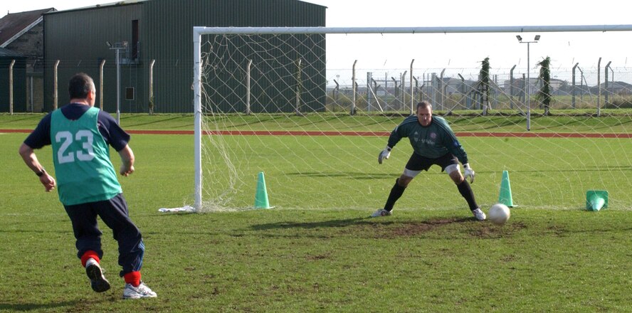 Fire Department Paul Cusden, slots the ball home past the 727th goalkeeper James Brown to give his team a dramatic win in a sudden-death penalty shoot-out to take the outdoor soccer championship at the RAF Mildenhall sports field Oct. 18. (U. S. Air Force photo by Airman 1st Class Brad Smith)