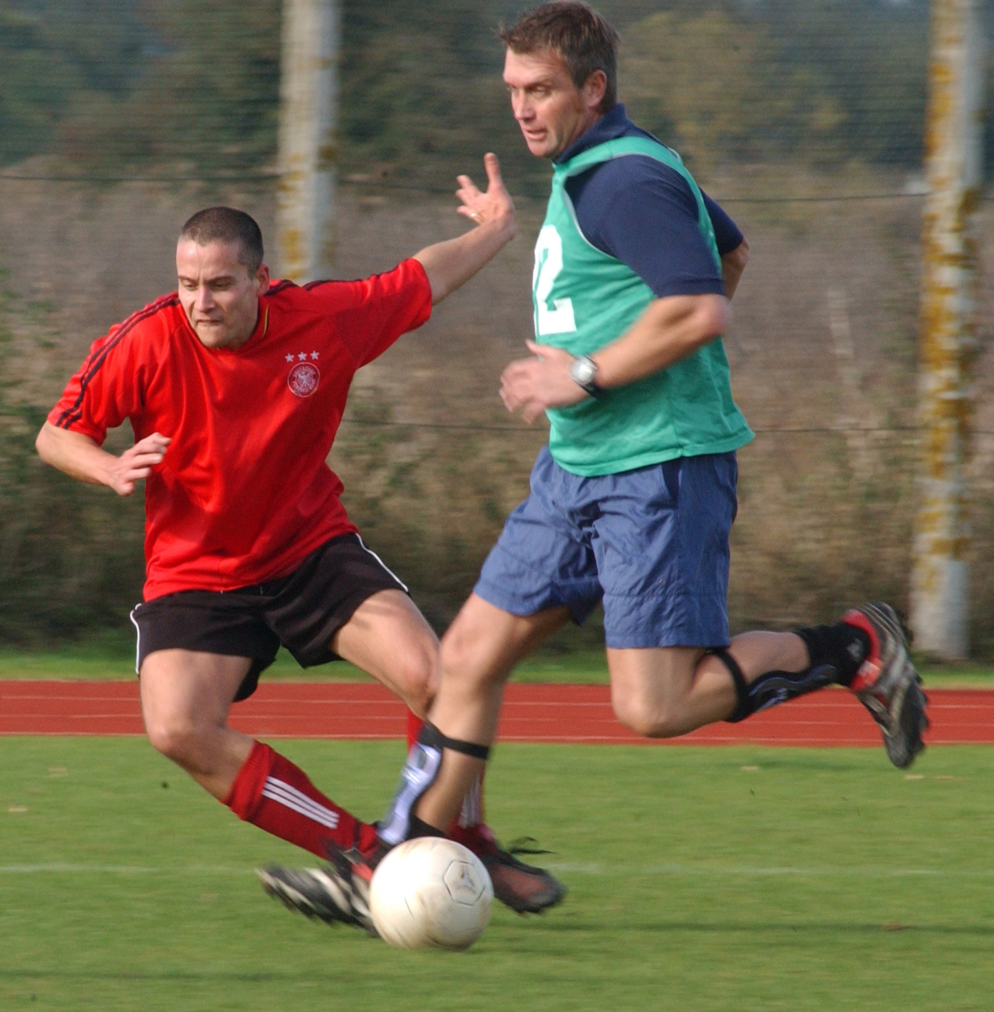 Ken Cross (in green), from the Fire Department, brushes aside 727th player James Berry, during the battle of the top two seeds in the outdoor soccer championships held at the RAF Mildenhall sports field Oct. 18. (U. S. Air Force photo by Airman 1st Class Brad Smith)