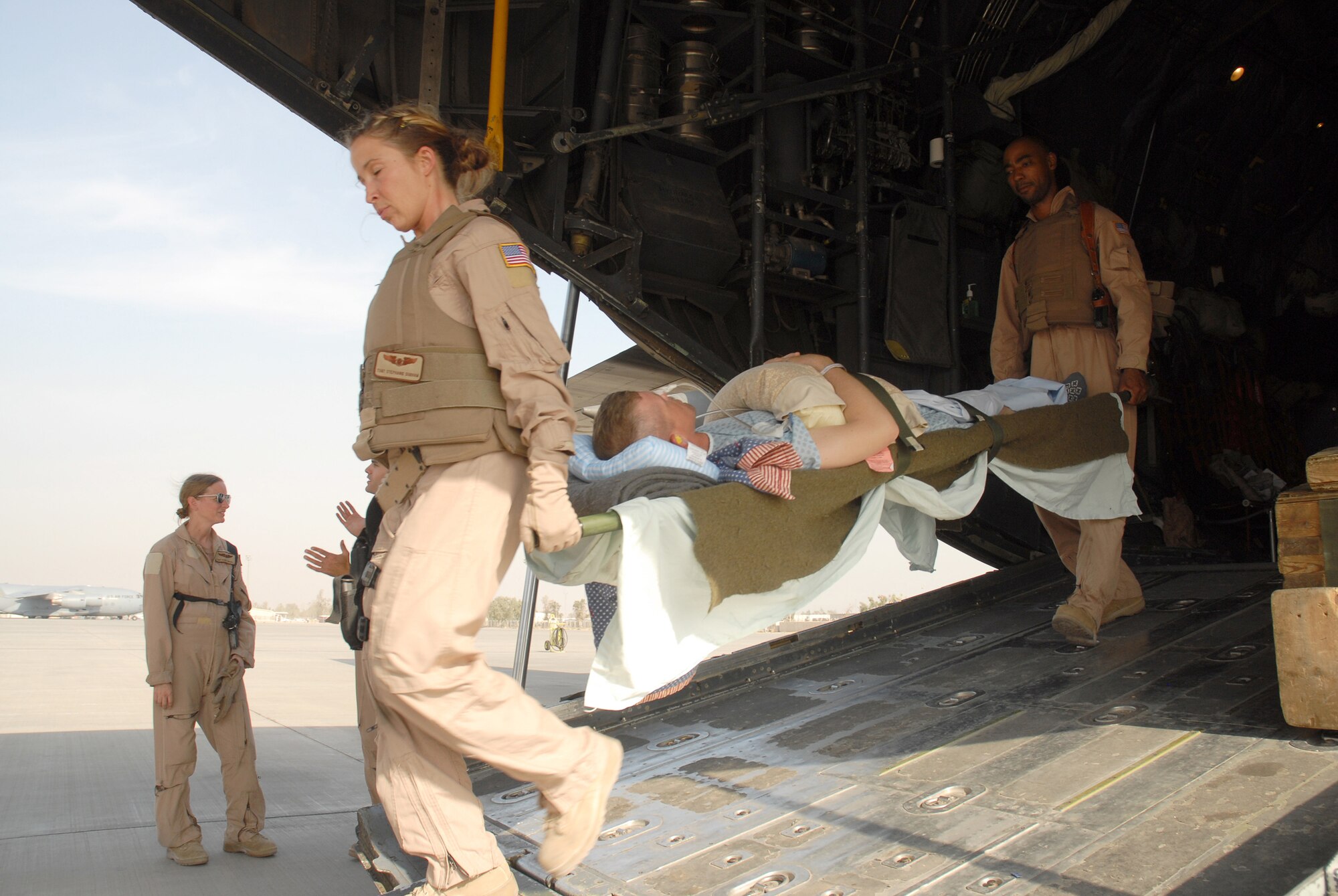 SOUTHWEST ASIA - Tech. Sgts. Stephanie Durham and Ricardo Brown carry a patient from a C-130 Hercules on a litter Oct. 14. Sergeant Durham, from Panama City, Fla, is deployed to Southwest Asia from Pope Air Force Base, N.C. Sergeant Brown, from Wichita Falls, Texas, is deployed from Scott AFB, Ill.  Personnel from the 379th Expeditionary Aeromedical Evacuation Squadron work to move and treat patients throughout the Southwest Asia theatre. (U.S. Air Force photo/Staff Sgt. Douglas Olsen)