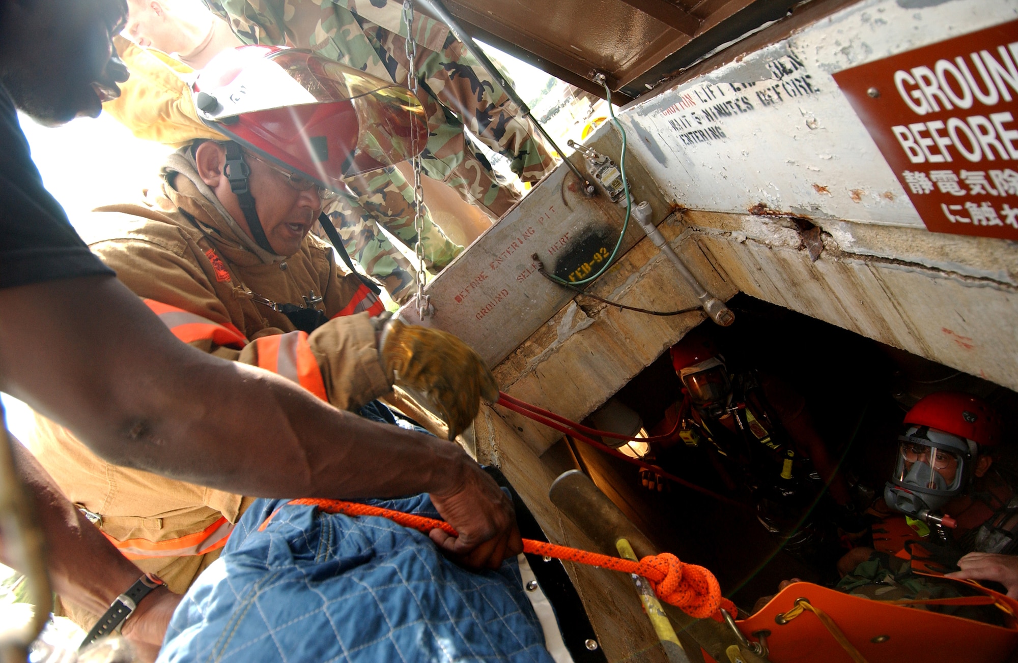 Airmen from the 18th Civil Engineer Squadron fire department pull up an unconscious "victim" during the Local Operational Readiness Exercise here Oct. 22. In the scenario an explosion at a fuel farm caused injuries to several people.  (U.S. Air Force photo/Tech. Sgt. Rey Ramon)