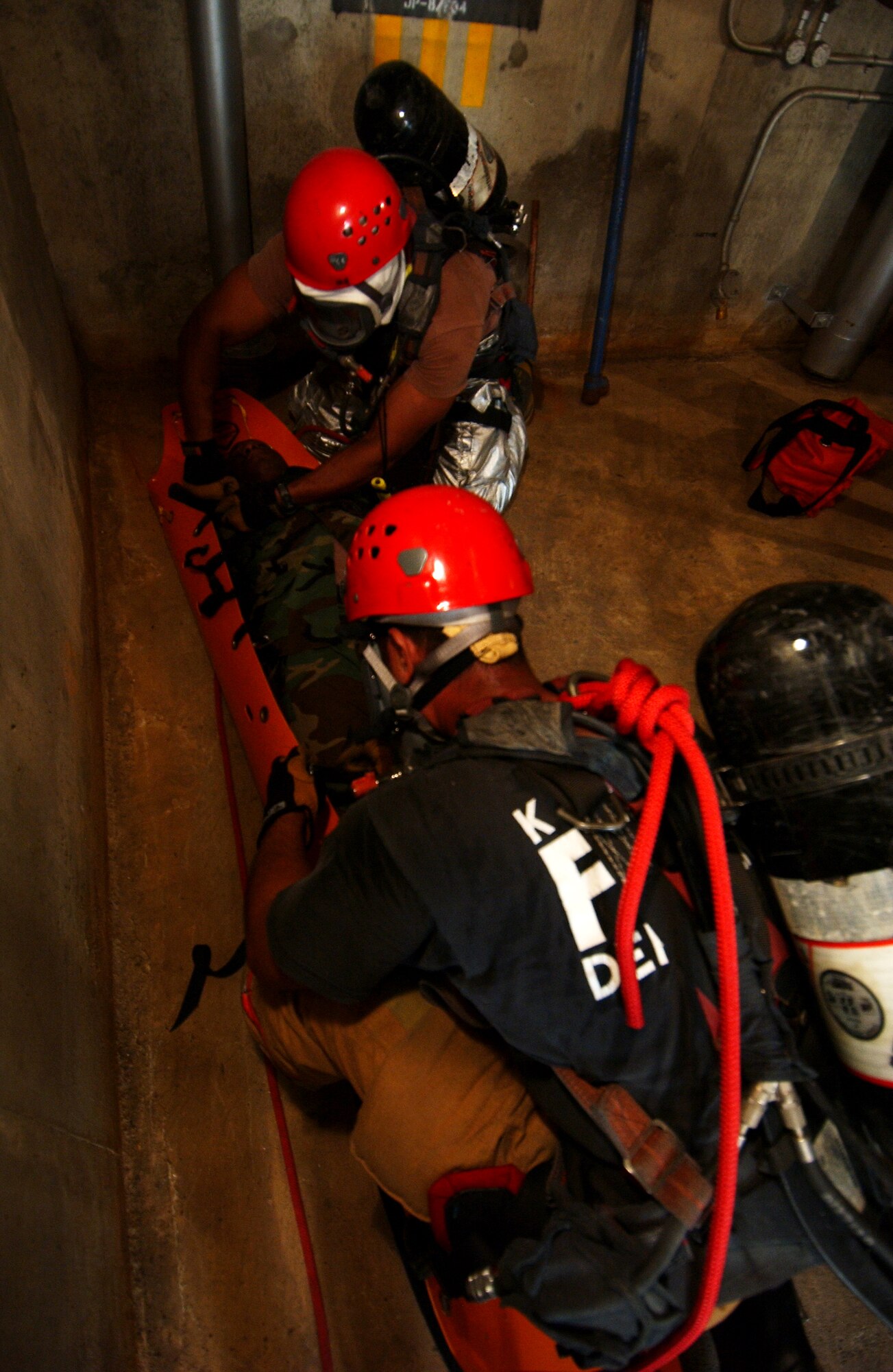 Members of the 18th Civil Engineer Squadron fire department attempt to rescue an unconscious "victim" during the Local Operational Readiness Exercise here Oct. 22. In the scenario an explosion at a fuel farm caused injuries to several people.  (U.S. Air Force photo/Tech. Sgt. Rey Ramon)