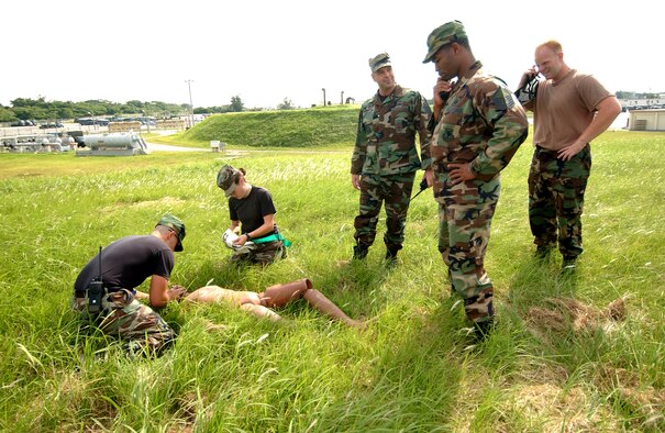 Airman 1st Class William Judge and Airman 1st Class Daniel Reed, 18th Logistics Readiness Squadron, simulate rescue breathing on a "victim" during a Local Operation Readiness Exercise here Oct. 22. In the scenario a gas explosion caused injuries to several people. 
(U.S. Air Force photo/Tech. Sgt. Rey Ramon)

