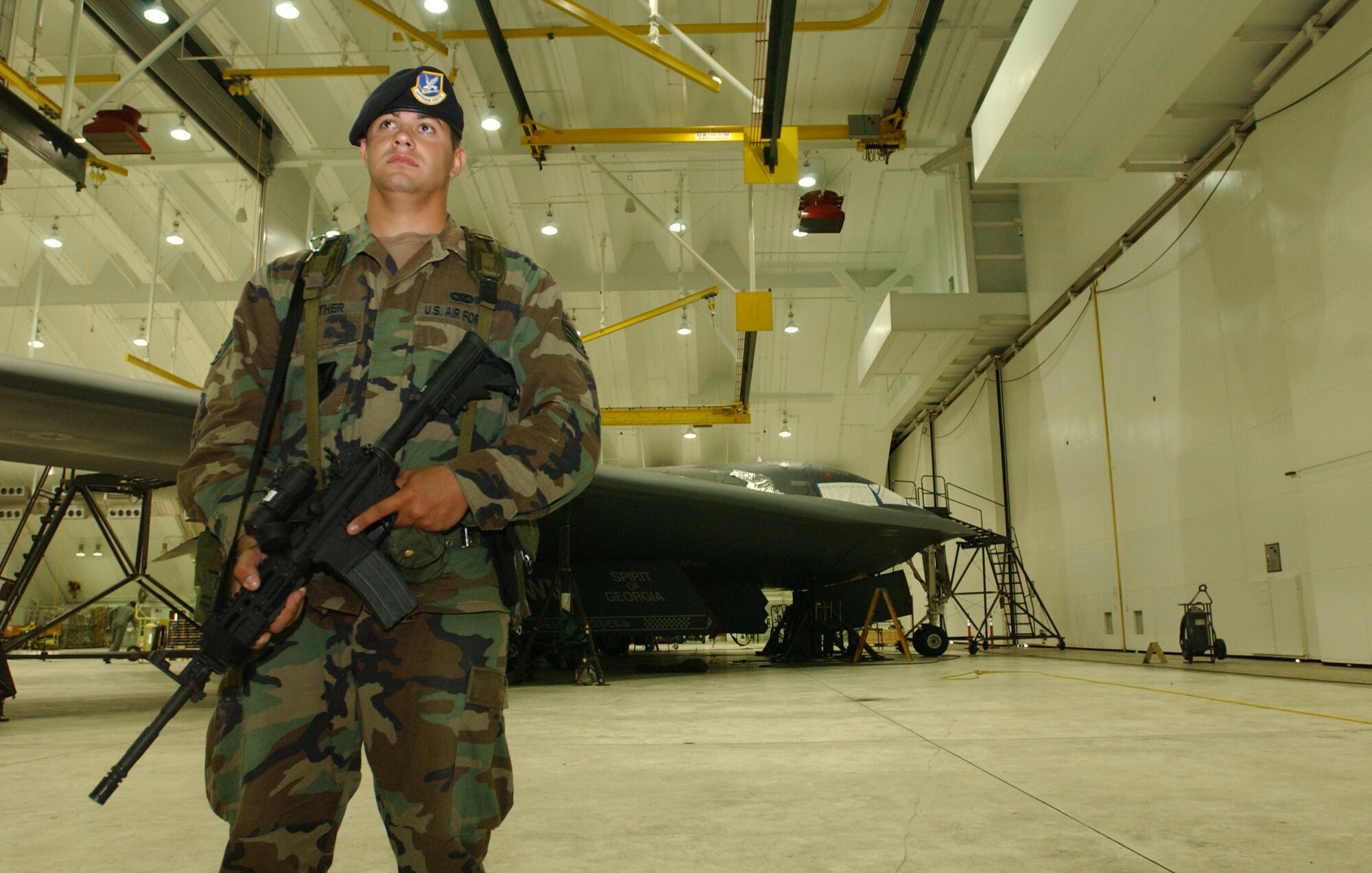 Senior Airman William Luther, 36th Security Forces Squadron, keeps a watchful eye on likely avenues of approach intruders or unauthorized personnel may use to harm this B-2 Spirit. Airman Luther is part of a crack team of security forces specialists who are responsible for the security of America’s most advanced bomber. (Air Force photo/Senior Airman Brian Kimball)