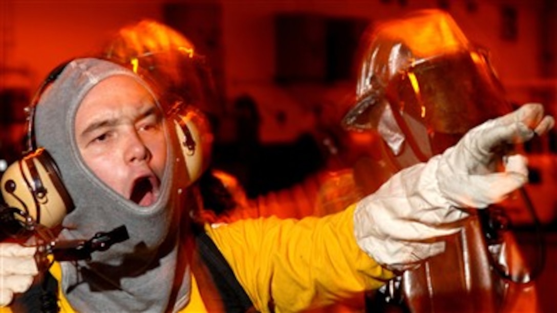 U.S. Navy Aviation Boatswain's Mate 3rd Class Robert Stuns directs a hose team toward a simulated aircraft fire while acting as the on-scene leader in the hangar bay of the Nimitz-class aircraft carrier USS Abraham Lincoln (CVN 72) during a general quarters drill on Oct. 20, 2007. The Lincoln is underway in the Pacific Ocean for a workup to include composite training unit exercise, an exercise designed to enhance the interoperability of the carrier and its strike group. 