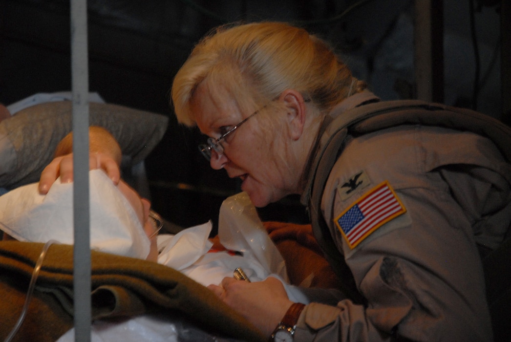 Col. Diane Fletcher speaks with a patient over the noise of an inflight C-130 Hercules Oct. 14, 2007 in Southwest Asia. Fletcher is deployed from Scott Air Force Base, Illinois. (U.S. Air Force photo by Staff Sgt. Douglas Olsen)