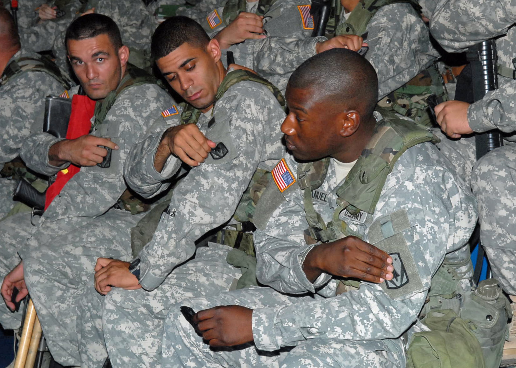 GIMHAE AIR BASE, Republic of Korea -- Three soldiers with Delta Battery, 1st Battalion, 44th Air and Missile Defense Battalion, rip off their previous battalion patch and replace it with the 35th Air Defense Artillery Brigade to symbolize their move under the new brigade. (U.S. Army photo by Pfc. Gretchen N. Goodrich)