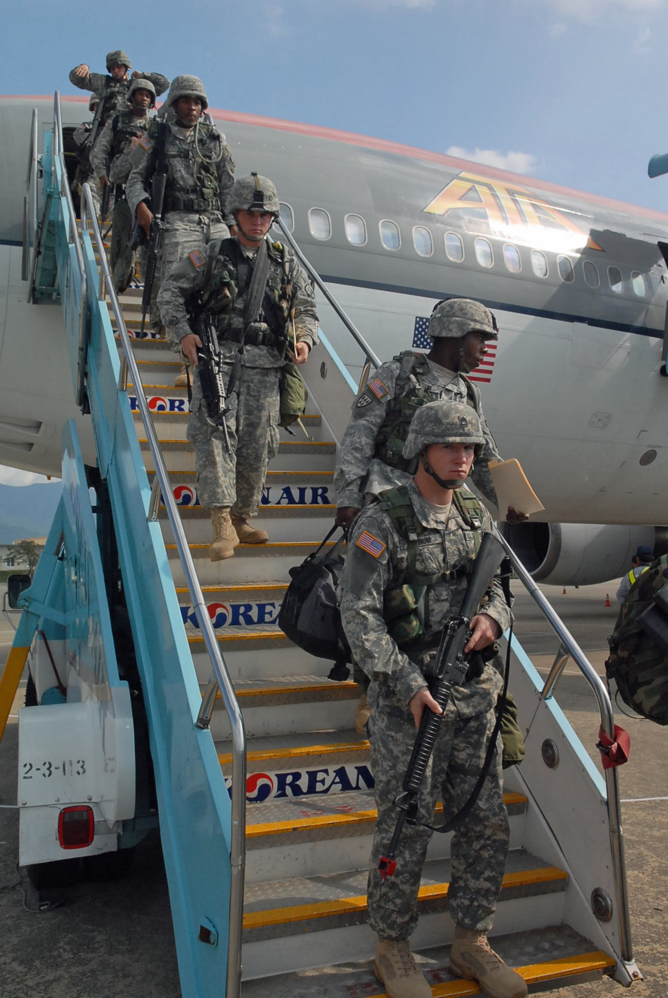 GIMHAE AIR BASE, Republic of Korea -- Soldiers with the 1st Battalion, 44th Air and Missile Defense Battalion, take their first steps out of the plane and onto the Korean soil after landing Oct. 18. (U.S. Army photo by Pfc. Gretchen N. Goodrich)