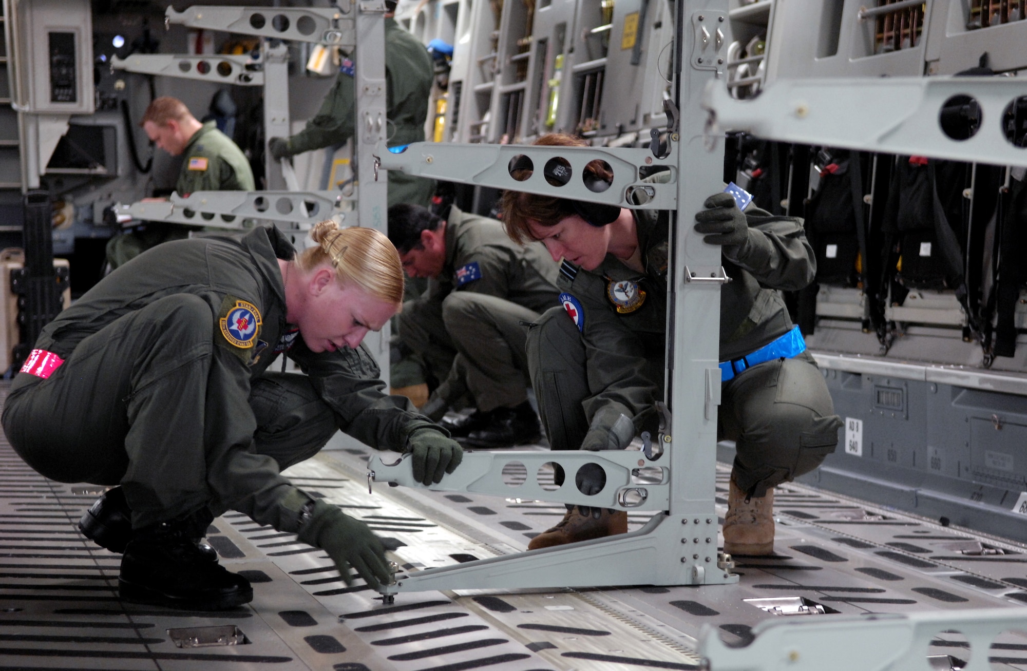 HICKAM AIR FORCE BASE, Hawaii -- Staff Sgt. Kristen Lewis and Flight Lt. Michelle Cole set up litter racks on a C-17 Globemaster III Oct. 16, 2007 during aeromedical evacuation operations training at Hickam Air Force Base, Hawaii. The 18th Aero Medical Squadron from Kadena Air Base, Japan is at Hickam to train Royal Australian Air Force medical personnel from the Health Services Wing the ins and outs of using equipment and the C-17 Globemaster III for aero medical evacuations. (U.S. Air Force photo/Tech. Sgt. Shane A. Cuomo) 
