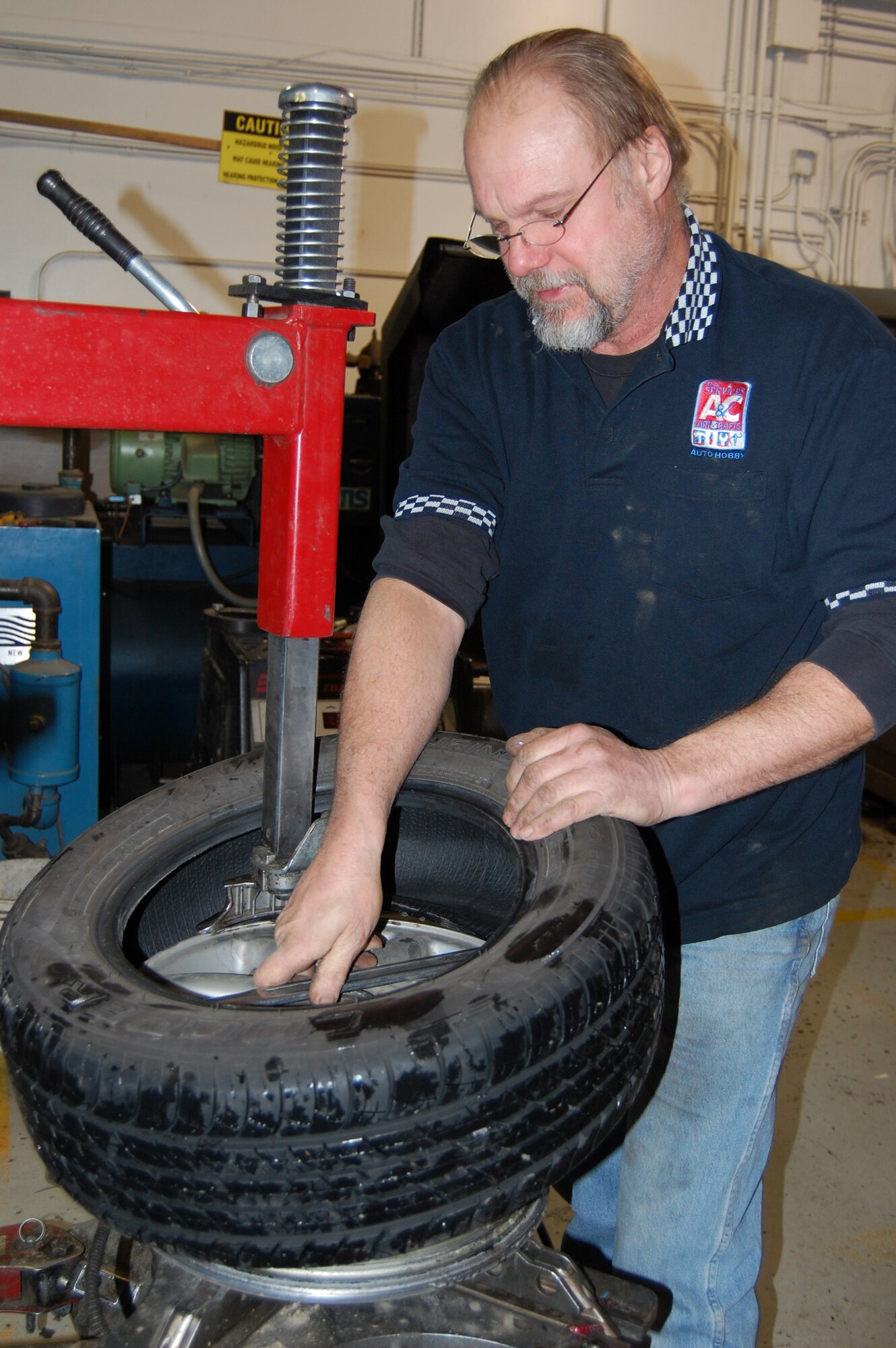 EIELSON AIR FORCE BASE, Alaska--Rick Bertz, Auto Skills Center manager, seperates a tire from the rim for in the process of switching out regular tires for snow tires Oct. 23 at the auto hobby shop. The shop is closed Mondays; open 10 a.m. to 8 p.m. Tuesdays, Wednesdays and Thursdays; 10 a.m. to 10 p.m. Saturdays and 1 to 6 p.m. Sundays. The shop is located at 2611 Arctic Blvd, for more information on auto hobby services, call 377-3190. (U.S. Air Force photo by Airman 1st Class Nora Anton)
