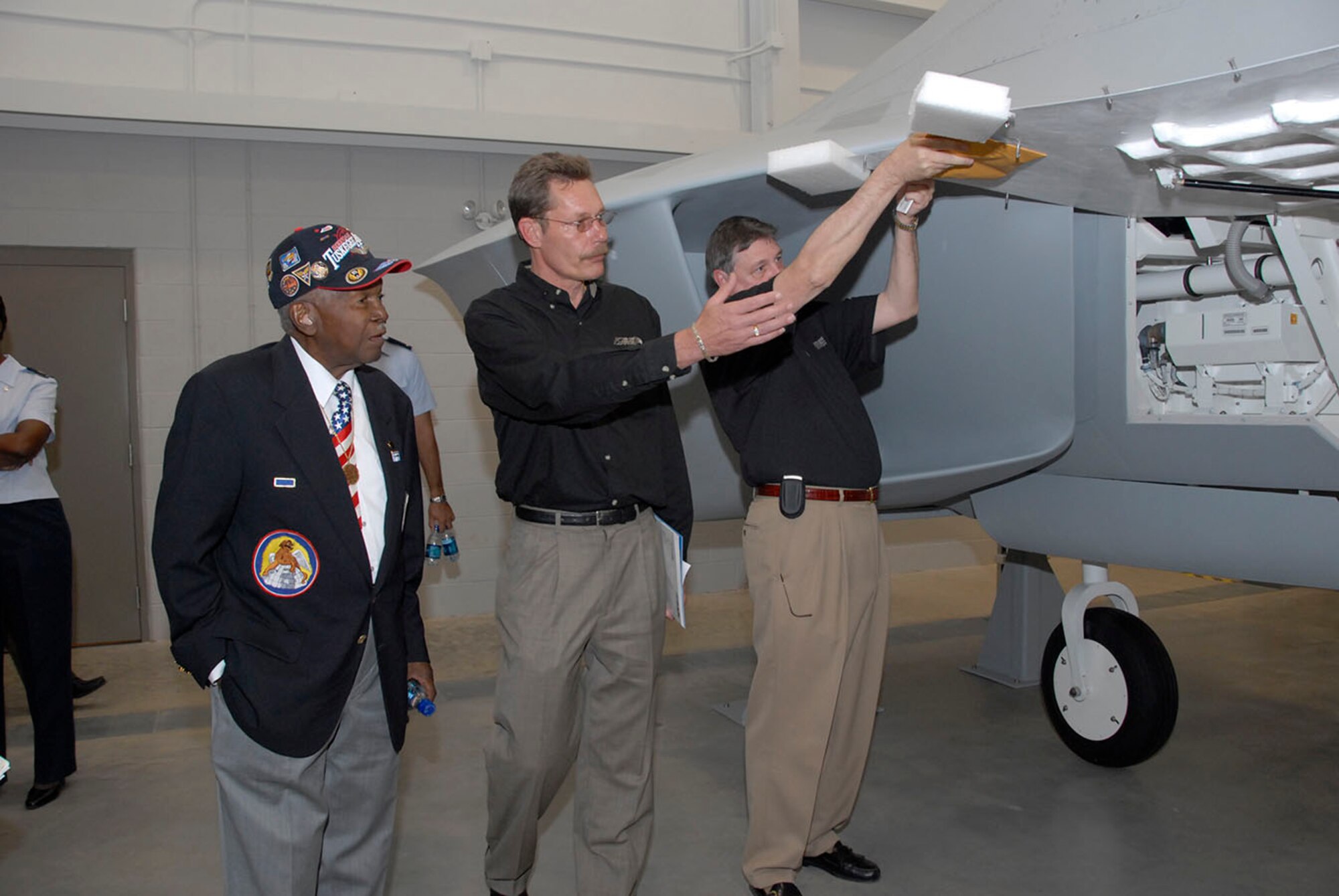 Members of the DME Corporation show off one of their F-22 Raptor Maintenance Trainers Oct. 19 at the F-22 Raptor Maintenance Training Facility opening. Come January the facility will train the second generation of Raptor maintaners for the Air Force. (U.S. Air Force photo/Sandy Wassenmiller)