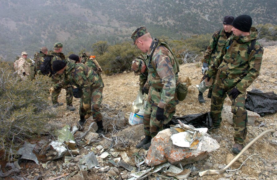 Volunteers line up to clean the initial impact site and corresponding side of the mountain. Most of the big pieces were cleaned up after the collision, but some smaller bits were left behind. (Air Force photo by Senior Airman Clay Murray)