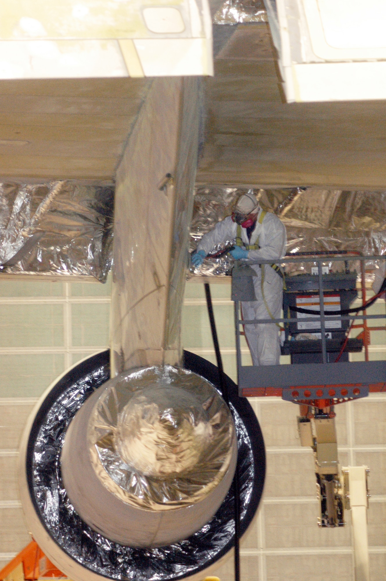 Joseph Newton sands a C-5 engine pylon in the Paint/Depaint facility at Warner-Robins Air Logistics Center. (U. S. Air Force photo/Sue Sapp)