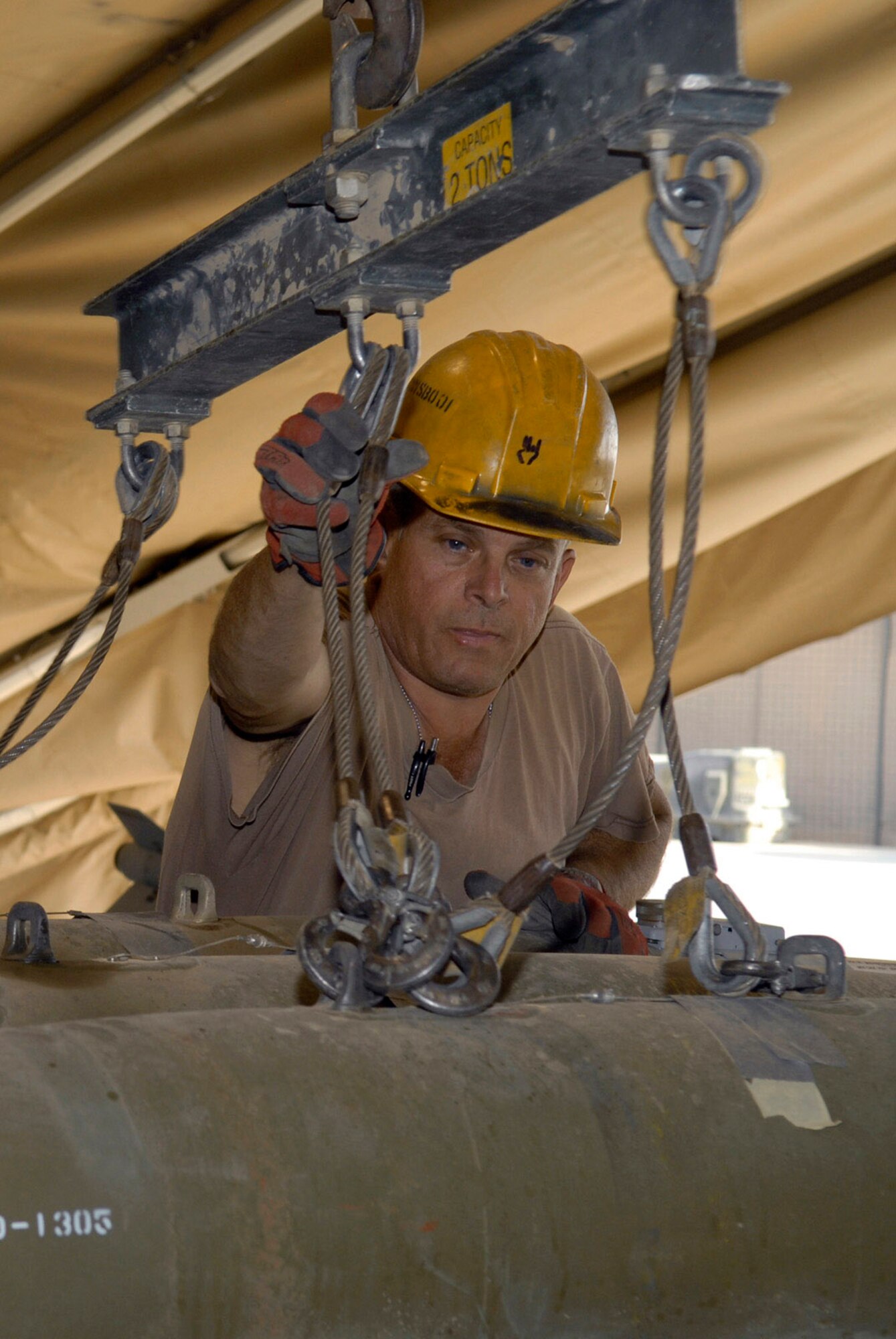 Tech. Sgt. Edmund Foerster uses a munitions assembly conveyor to load bombs onto a transport trailer Oct. 15 at Balad Air Base, Iraq. The conveyor allows personnel to move multiple munitions at one time. Sergeant Foerster is assigned to the 332nd Expeditionary Maintenance Squadron. (U.S. Air Force photo/Staff Sgt. Joshua Garcia)

