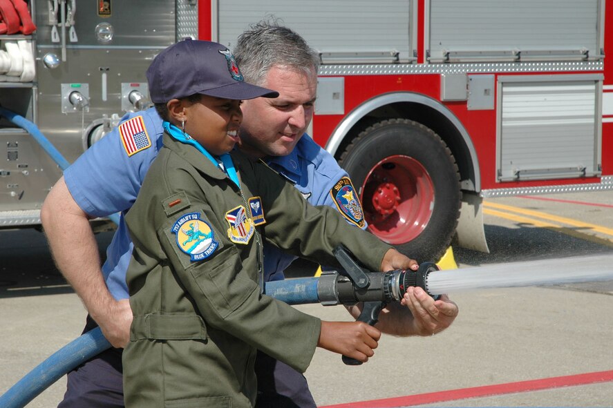 YOUNGSTOWN AIR RESERVE STATION, Ohio — Air Force Reserve Honorary 2nd Lt. Darian Hammond operates a fire hose with the help of Kevin Brichetto, a firefighter assigned to the 910th Civil Engineer Fire Department, as part of activities for the 910th Airlift Wing's 30th Pilot for a Day program event held here. U.S. Air Force photo/ Tech. Sgt. Bob Barko Jr.