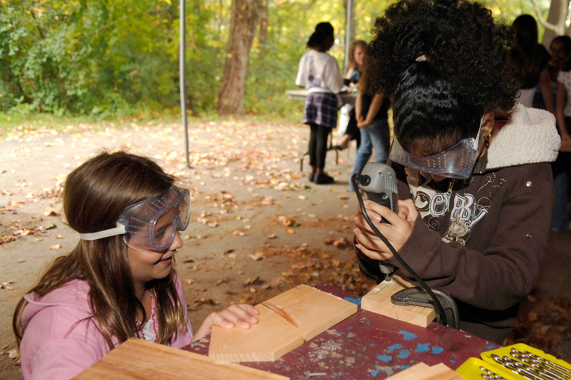 HANSCOM AFB, Mass. -- Brenna Gonsalves (left) and Julianne Sandoval have fun at the Youth Center while learning to use a power drill. (U.S. Air Force photo by Jan Abate)

