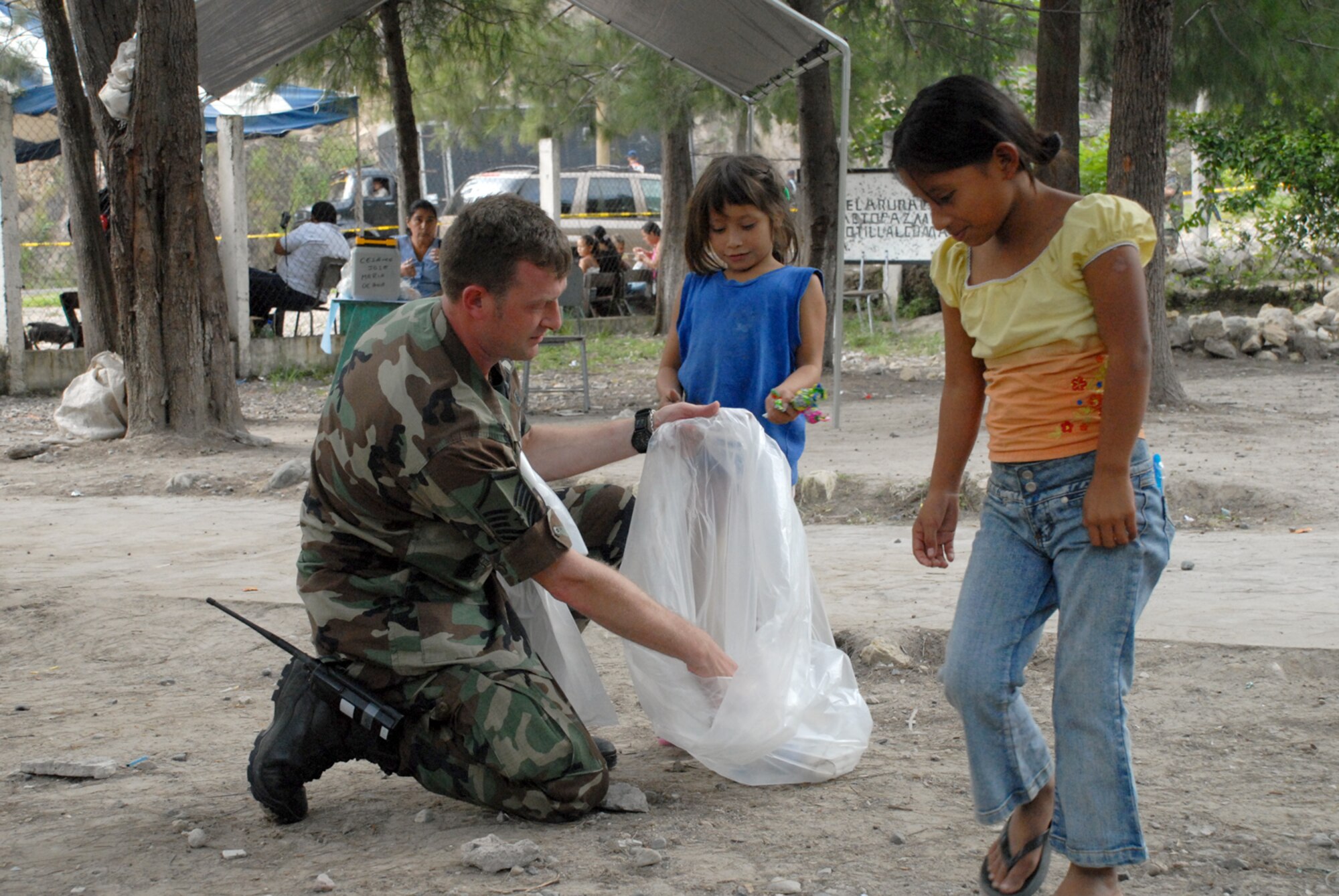 CUESTA DE LA VIRGEN, Honduras -- Air Force Master Sgt. Troy Himes, Joint Task Force-Bravo Medical Element emergency medical technician deployed from Wright-Patterson Air Force Base, takes time out to pick up litter with local Honduran children here Oct. 19.  Sergeant Himes participated in a MEDRETE that educated 785 Hondurans on preventive medicine issues such as hand washing, food preparation and personal hygiene.  Of those 785, doctors examined 352 patients and the dentist treated 139 patients. (U.S. Air Force photo/1st Lt. Erika Yepsen)