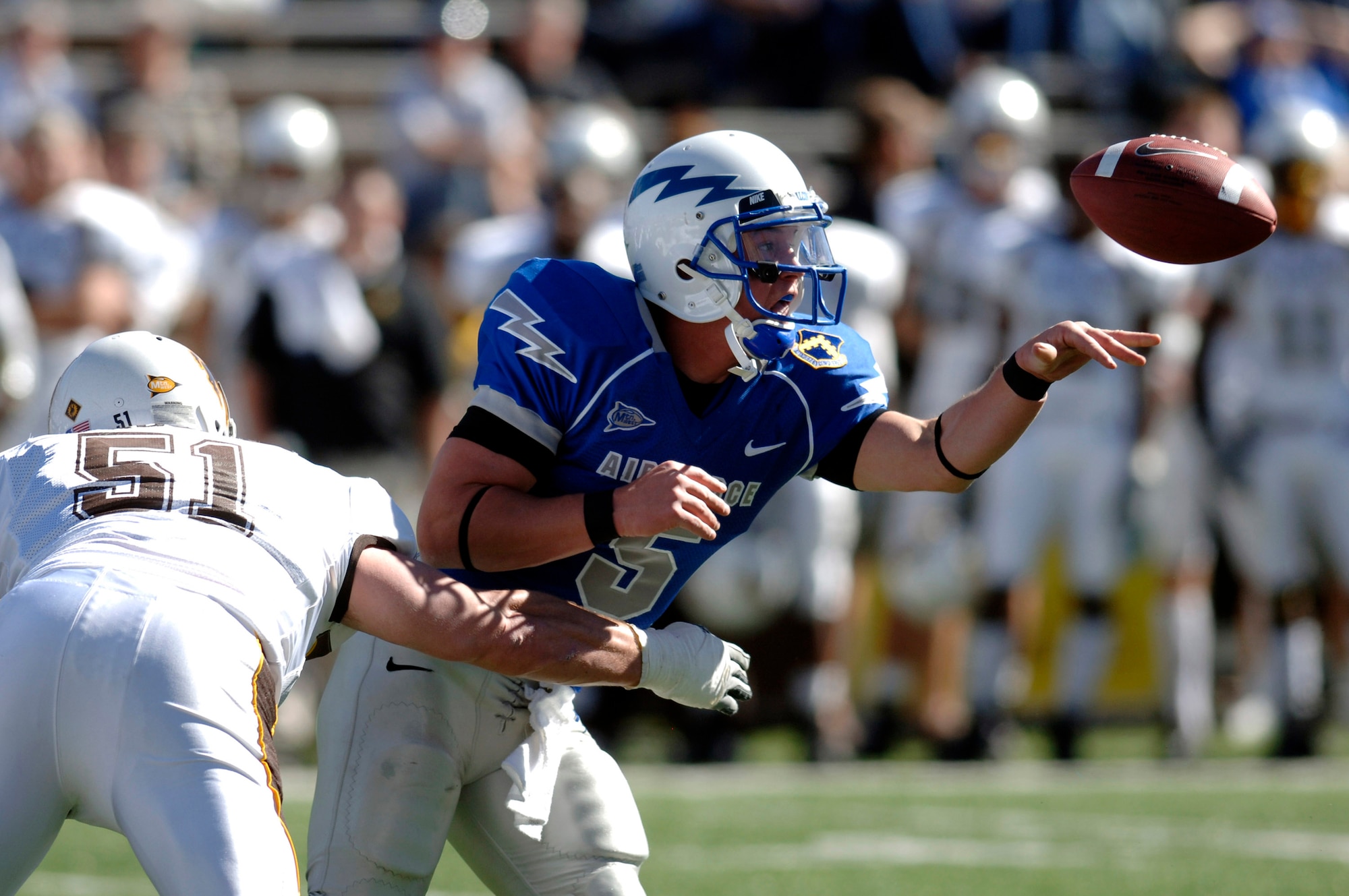 U.S. Air Force Academy Falcons quarterback Shaun Carney pitches to a teammate before getting hit by Wyoming's Brandon Haugen during Air Force's 20-12 win Oct. 20 at Falcon Stadium in Colorado. Carney ran for 64 yards and passed for 52 more. (U.S. Air Force photo/Mike Kaplan) 
