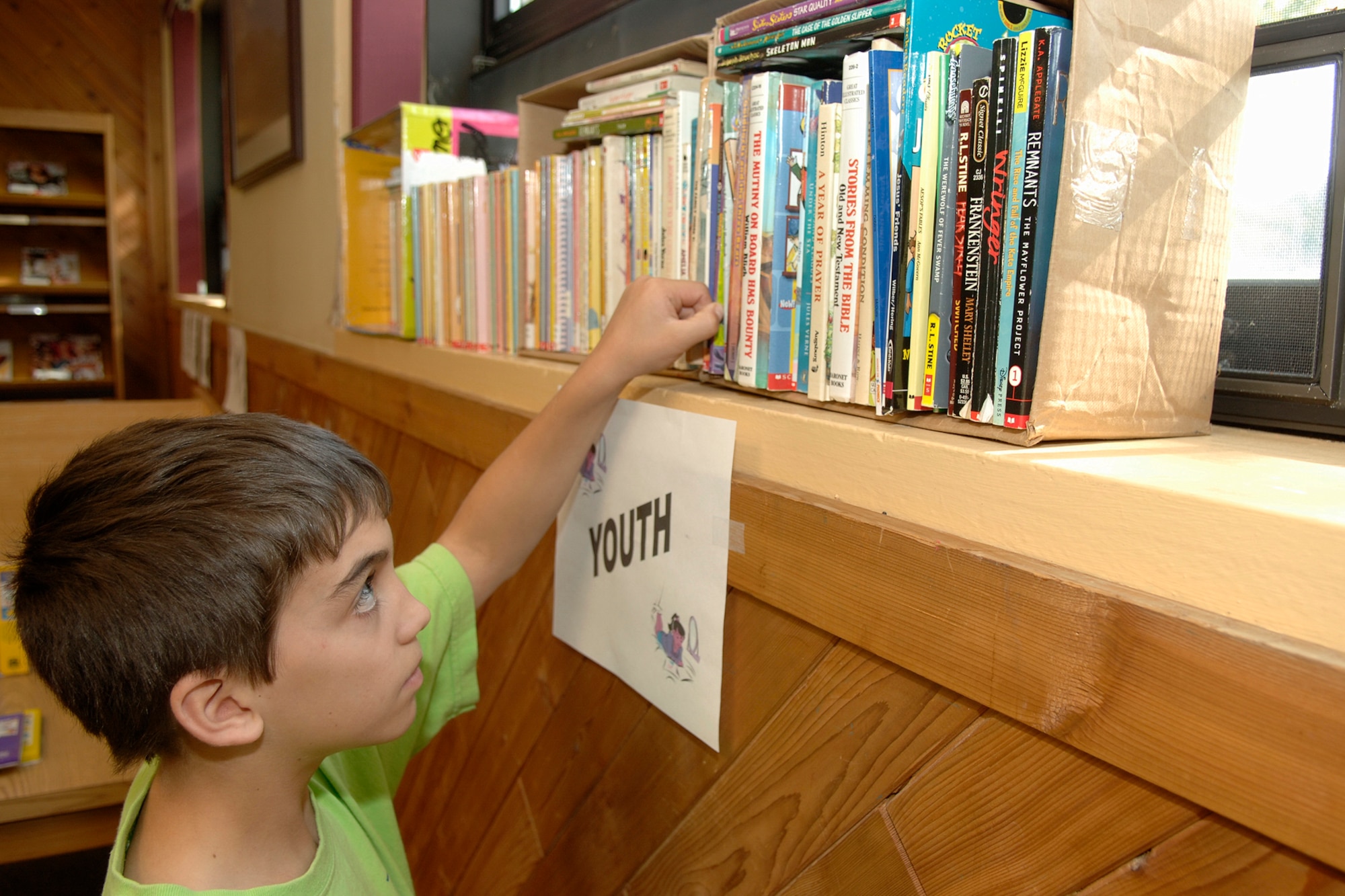 HANSCOM AFB, Mass. -- Scott Armfield, 9, reaches for a book on display during a book fair at the Base Library Oct. 17. (U.S. Air Force photo by Jan Abate)

