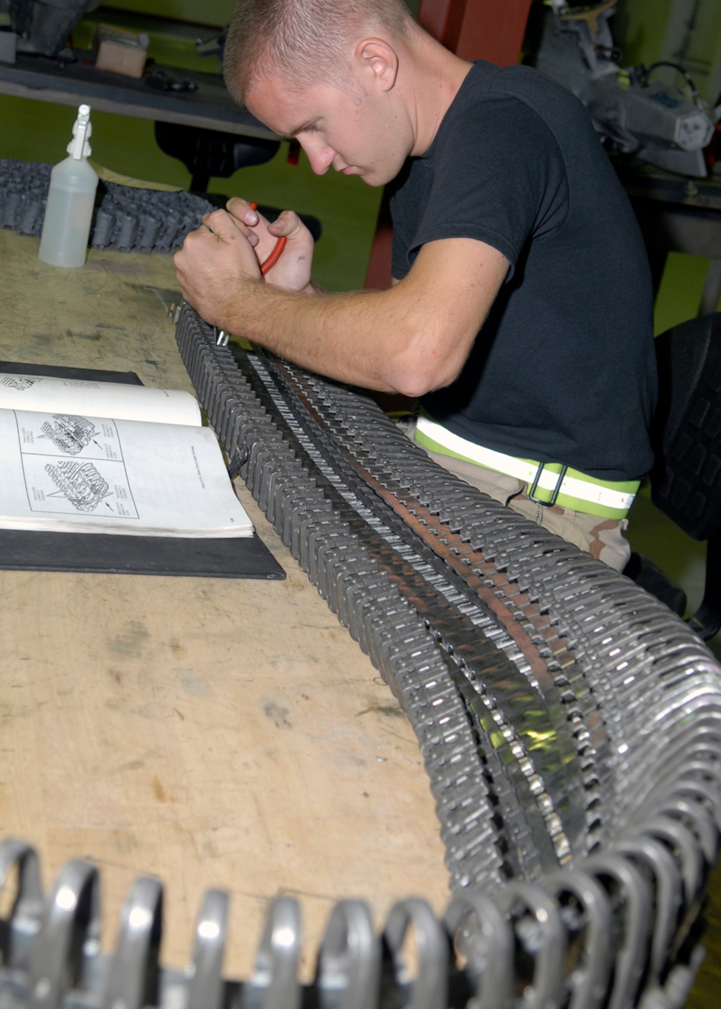 Staff Sgt. Alec Cawlfield repairs a damaged section of the feed chute of a universal ammunition loading system Oct. 22 in his maintenance shop at Balad Air Base, Iraq. The feed chute is used to load the bullets into the aircraft. Sergeant Cawlfield is deployed from the Indiana Air National Guard's 122nd Fighter Wing in Ft. Wayne. He is assigned to the 332nd Expeditionary Maintenance Squadron. (U.S. Air Force photo/Staff Sgt. Joshua Garcia)