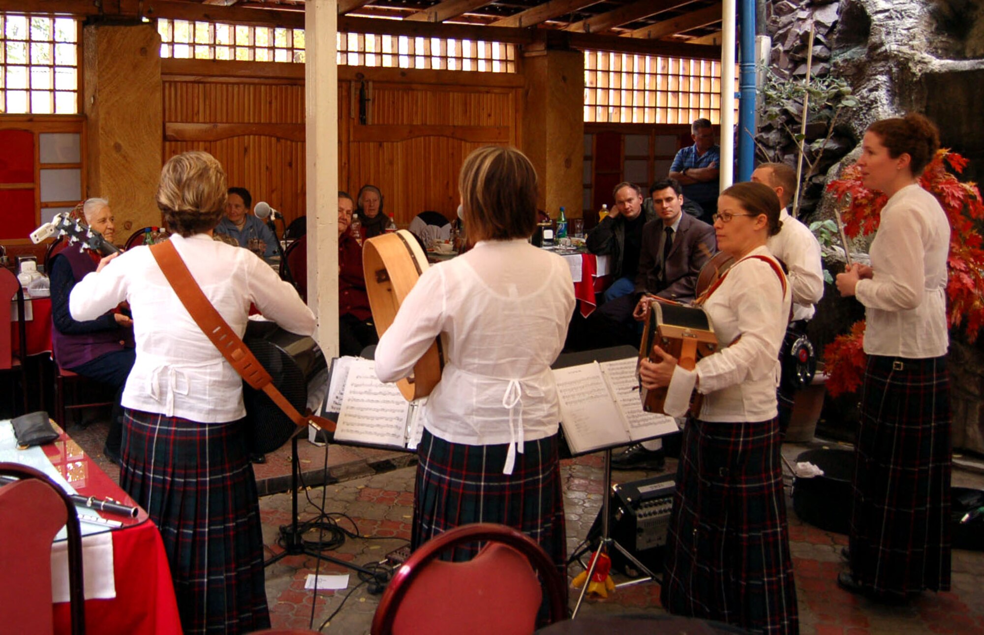 The U.S. Central Command Air Forces band, "Desert Ramblers," performs for elderly Kyrgyz women who have no families. Band members, who play traditional and contemporary Celtic music, and Airmen from nearby Manas Air Base, Kyrgyzstan, treated the women to lunch and a show at a local restaurant. The visit was part of the Manas Air Base Outreach Society volunteer program, which works with existing Kyrgyz organizations and provides community service support to 10 organizations that work with children, the elderly, handicapped and other disadvantaged groups. (U.S. Air Force photo/Capt. Michael Murray) 