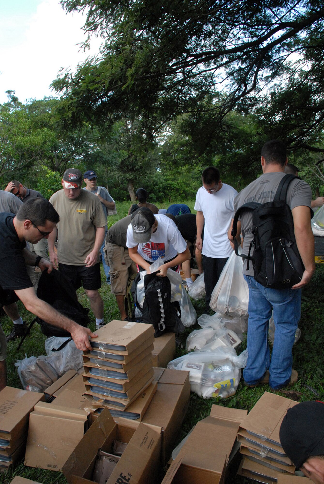 American servicemembers load their packs and backpacks with food Oct. 20 to deliver to people in the village of Bella Vista, Honduras. The hike was organized by the Joint Task Force Bravo chaplain to support local Hondurans. Approximately 50 servicemembers from Soto Cano Air Base, Honduras, participated in the hike. (U.S. Air Force photo/1st Lt. Erika Yepsen) 
