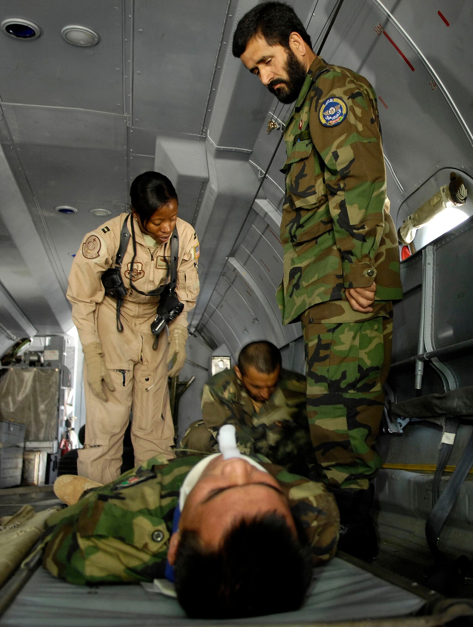 Capt. Marilyn Thomas observes a medical evacuation team as they floor load a patient onto an AN-32 cargo plane during a training exercise held at Kabul International Airport.  Captain Thomas is flight nurse and an Afghan National Army Air Corp medical mentor with the Air Corp Advisors Group here. She is deployed from Scott Air Force Base and her hometown is Beaver Creek, Ohio.    (U.S. Air Force photo/Staff Sgt. Brian Ferguson)