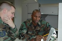 YOUNGSTOWN AIR RESERVE STATION, Ohio — Tech Sgt. Khalid Mulazim points out a finance issue to Staff Sgt. Michael Hollows during the October UTA here. Both sergeants are military pay technicians in the 910th AW Finance office. This summer, Sergeant Mulazim became the national champion in the men?s 400-meter dash at the USA National Masters Championship meet in Maine. U.S. Air Force photo/Senior Airman Ann Wilkins Jefferson