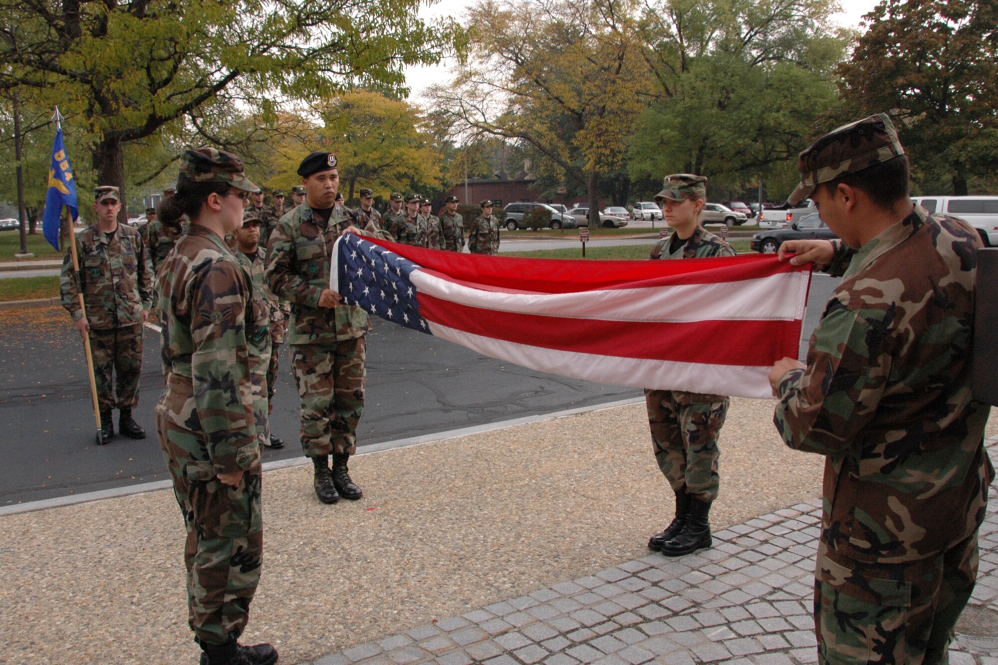 From left, Airman 1st Class Melissa Nguyen, Capt. Michael Nedrow, 1st Lt. Christie Jones and Senior Airman Nathan Lopez, all 554th Electronic Systems Wing personnel, fold the U.S. flag during a Retreat Ceremony held outside of building 1606 Oct. 18. (U.S. Air Force photo by Dennis Lewis.)
