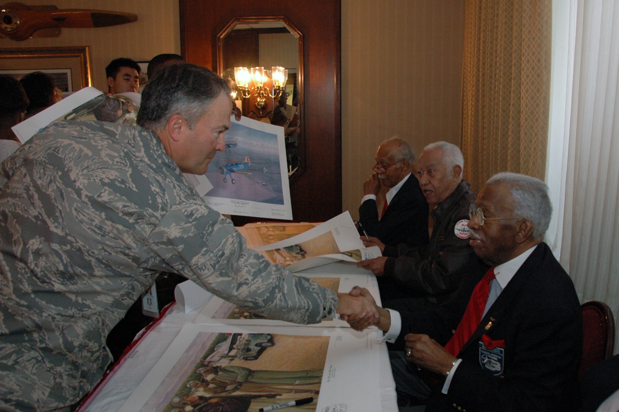 From left, Maj. Gen. Art Rooney, Electronic Systems Center vice commander, shakes hands with Willis Saunders, Original Tuskegee Airman, during a reception held at the Minuteman Club Oct. 19 in honor of the Air Force’s 60th Anniversary. Original Tuskegee Airmen signed commemorative memorabilia for Hanscom personnel, and reminisced about their time in service. Following the reception was an afternoon trip to the Collings Foundation’s Living History private exhibit in Stow, Mass., featuring World War II aircraft. (U.S. Air Force photo by Dennis Lewis)
