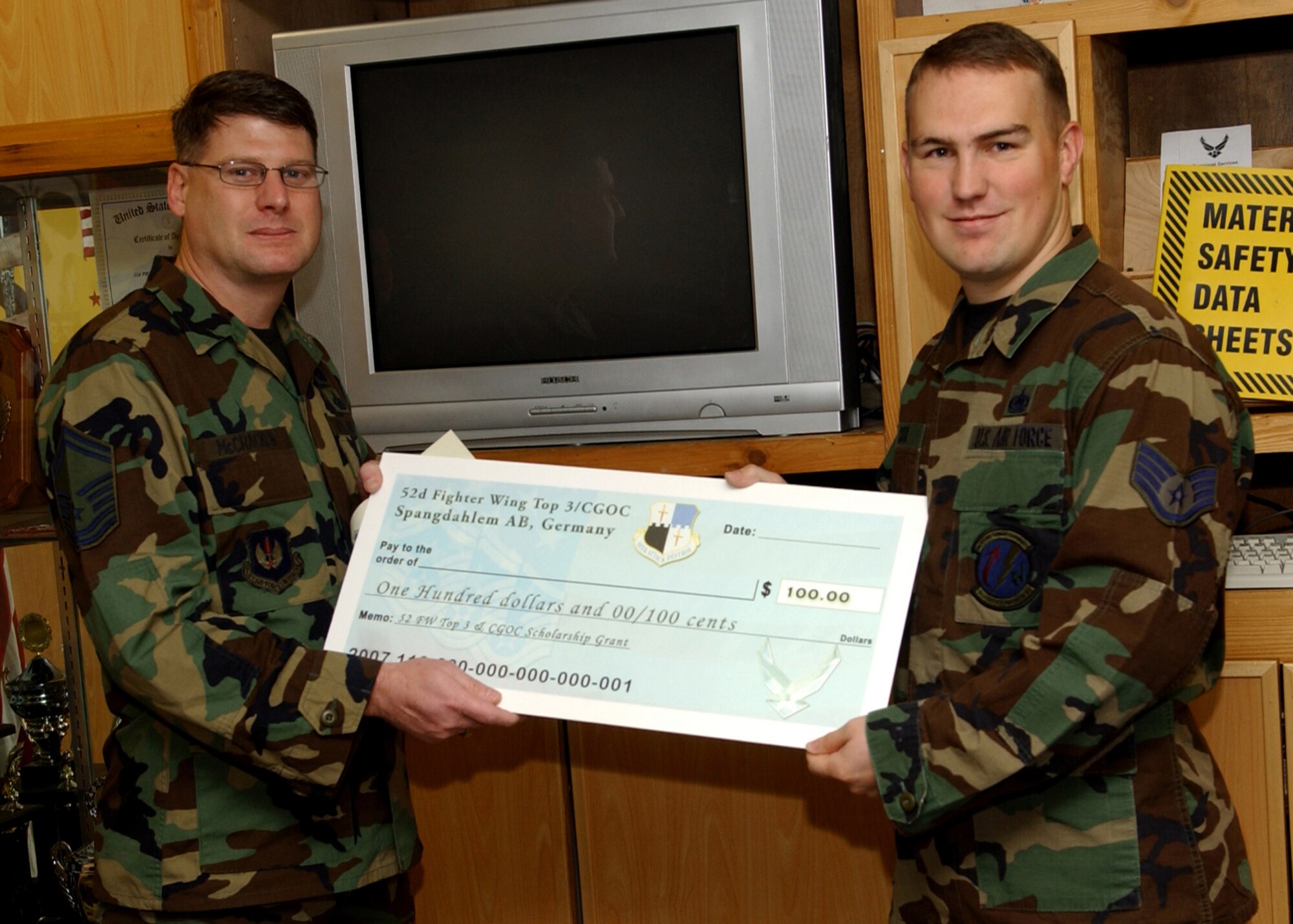 SPANGDAHLEM AIR BASE, Germany -- Senior Master Sgt. Patrick McCracken, 52nd Fighter Wing Top 3 Education Committee, presents Staff Sgt. Mathew Cox, 52nd Logistics Readiness Squadron, with a scholarship check for $100. The Top 3 and Company Grade Officer Council have teamed up to present two $100 scholarships each term in order to encourage Airmen and junior NCOs to continue their off-duty education. (U.S. Air Force photo/Airman 1st Class Allen Pollard)     