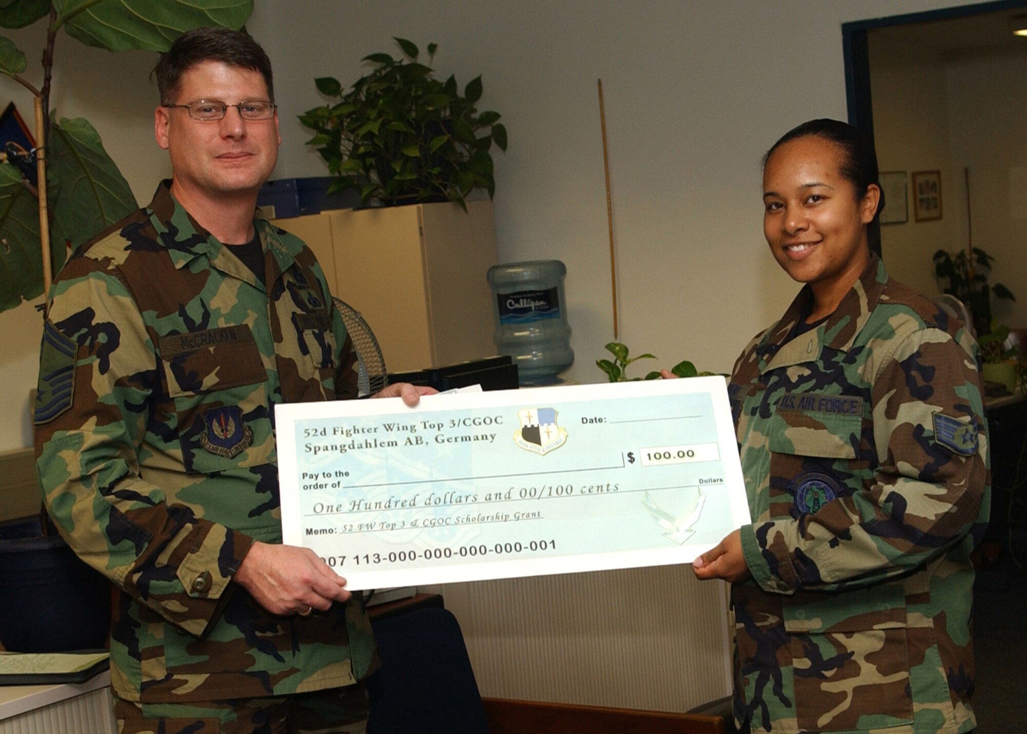 SPANGDAHLEM AIR BASE, Germany -- Senior Master Sgt. Patrick McCracken, 52nd Fighter Wing Top 3 Education Committee, presents Staff Sgt. Tashiana Sanders, 52nd Communications Squadron, with a scholarship check for $100. The Top 3 and Company Grade Officer Council have teamed up to present two $100 scholarships each term in order to encourage Airmen and junior NCOs to continue their off-duty education. (U.S. Air Force photo/Airman 1st Class Allen Pollard)     
