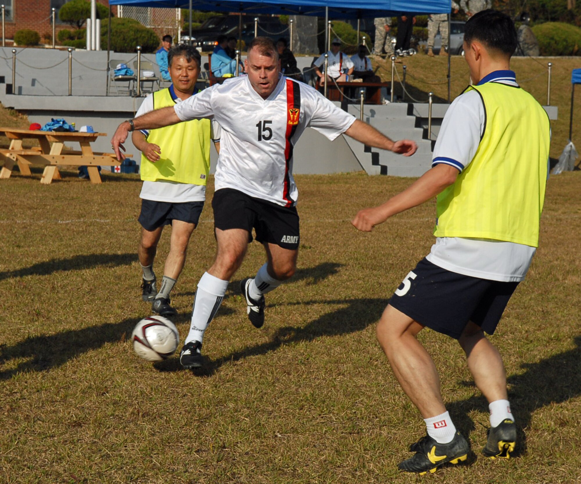 OSAN AIR BASE, Republic of Korea --  Lt. Col. Gerald M. Dailey, deputy commander of 35th ADA BDE, sweeps the soccer ball past two of the 2nd ADA BDE defenders during the Goodwill Soccer Match on Oct. 18. (U.S. Army photo by Pfc. Gretchen N. Goodrich)