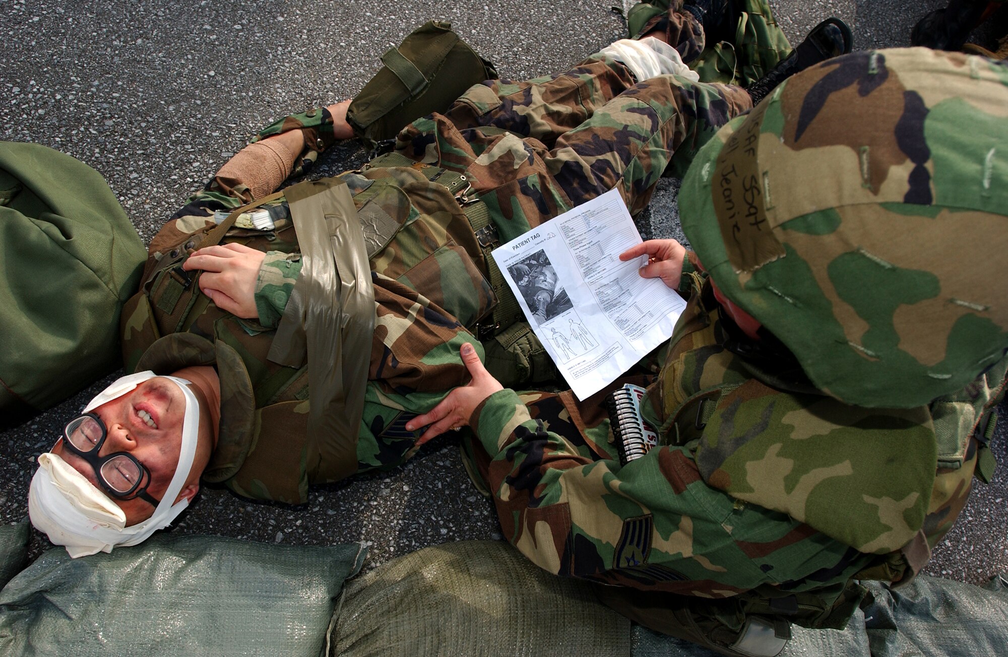 Staff Sgt. Jeanie Campbell, 18th Communications Squadron, cares for an injured Airman with multiple wounds and keeps the victim conscious during a simulated explosion at the 18th CS building at Kadena Air Base, Japan, Oct. 24, 2007. The mass casualty scenario helped Airmen train on treating wounds and applying basic life-saving steps during Local Operational Readiness Exercise Beverly High 08-1.  (U.S. Air Force photo/Tech. Sgt. Rey Ramon) 
