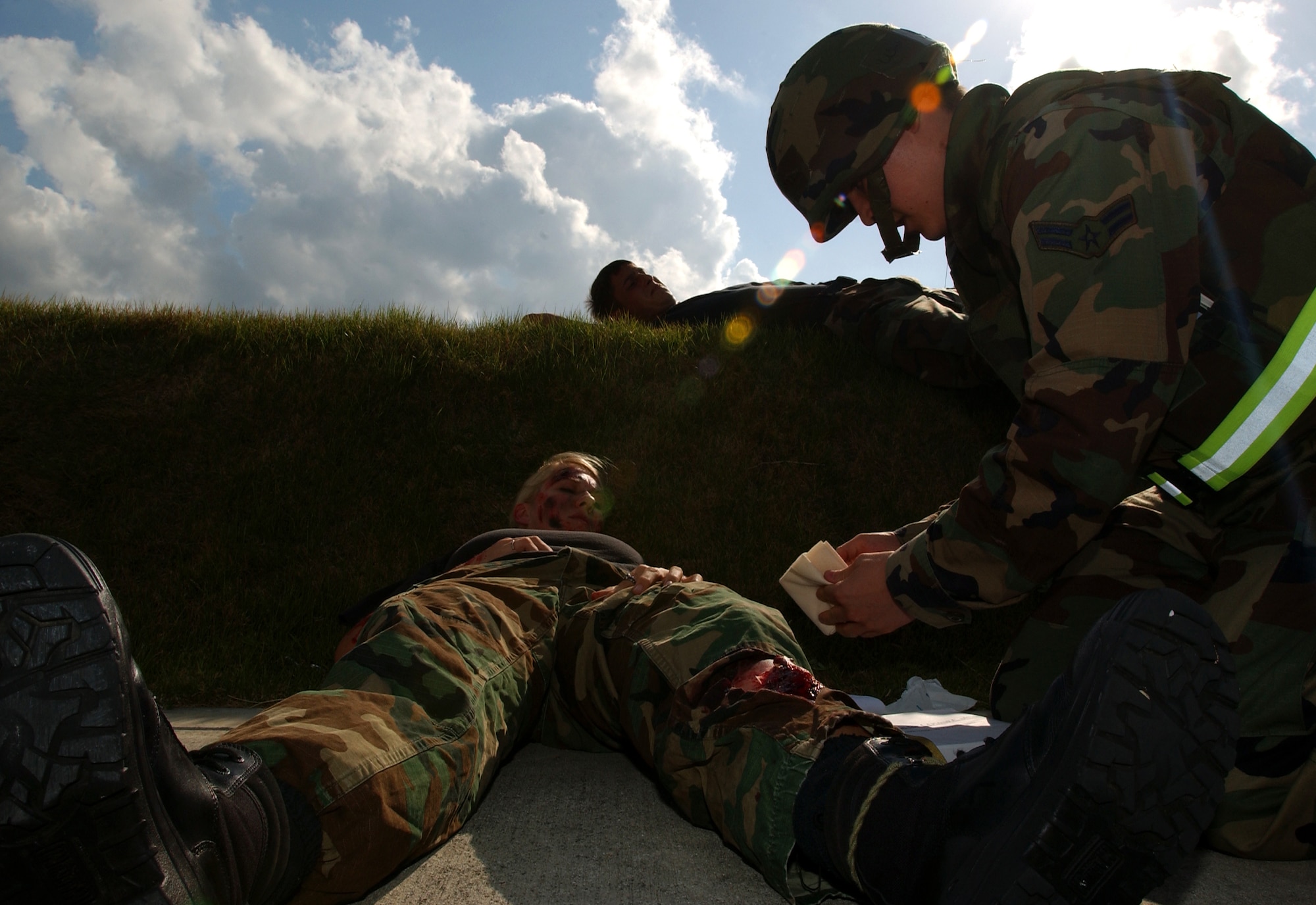Airman 1st Class John Ogami, 18th Communications Squadron, cares for an injured Airman during a simulated explosion in the 18th CS building at Kadena Air Base, Japan, Oct. 24, 2007. The mass casualty scenario helped Airmen train on treating wounds and applying basic life-saving steps in Local Operational Readiness Exercise Beverly High 08-1.  (U.S. Air Force photo/Tech. Sgt. Rey Ramon) 
