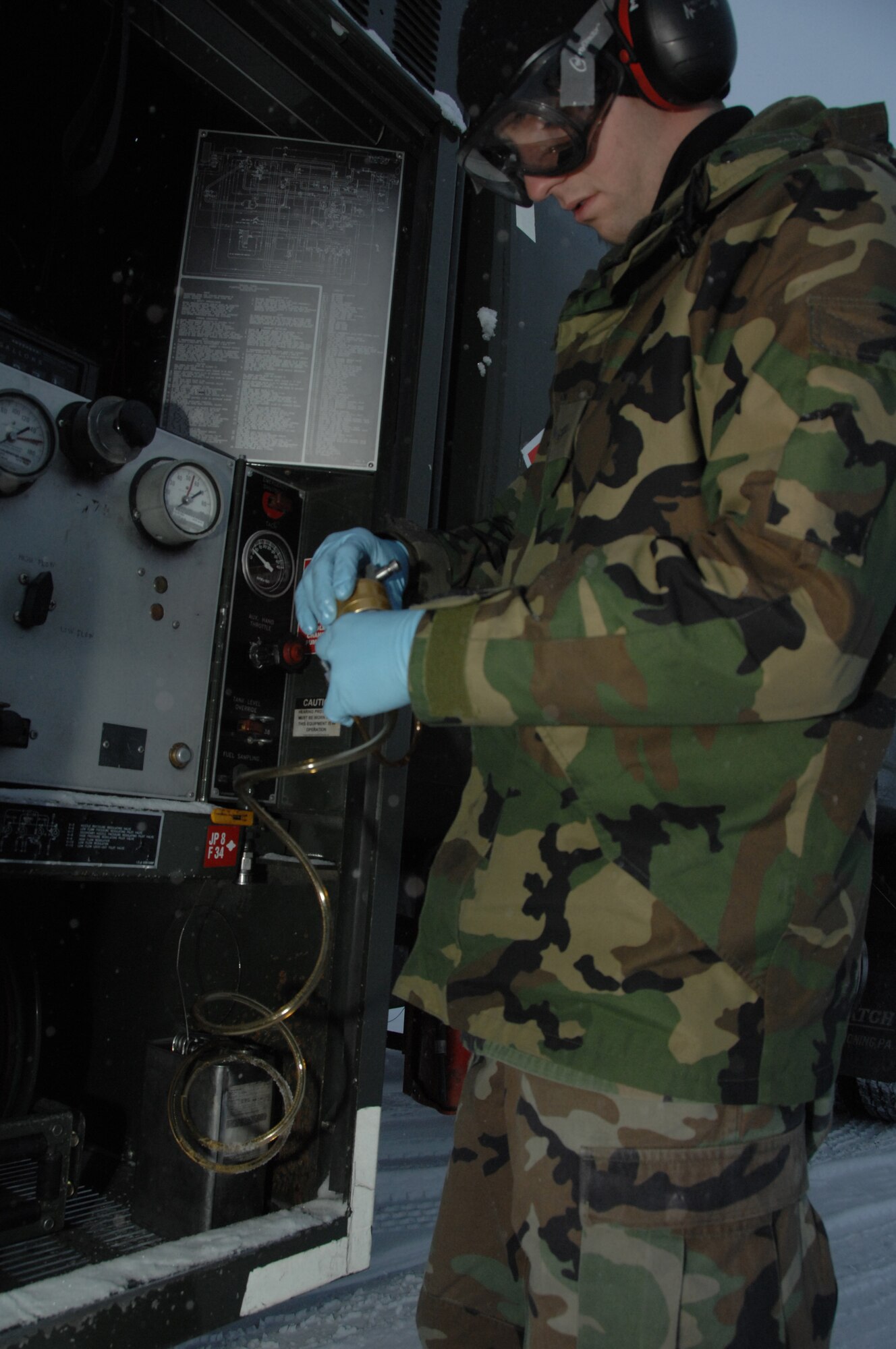EIELSON AIR FORCE BASE, Alaska --  Airman 1st Class Sean McDonagh, 354th Logistic Readiness Squadron fuels laboratory technician, prepares to connect a Gammon Inline Sampler to a truck’s fuel line Oct. 24, 2007, at the fuel’s yard. Making sure the fuel used by the aircraft here at Eielson is always good to go, Airman McDonagh helps assure the process by constantly sampling the fuel lines and also the trucks that distribute it to the aircraft. (U.S. Air Force photo by Airman 1st Class Christopher Griffin)
