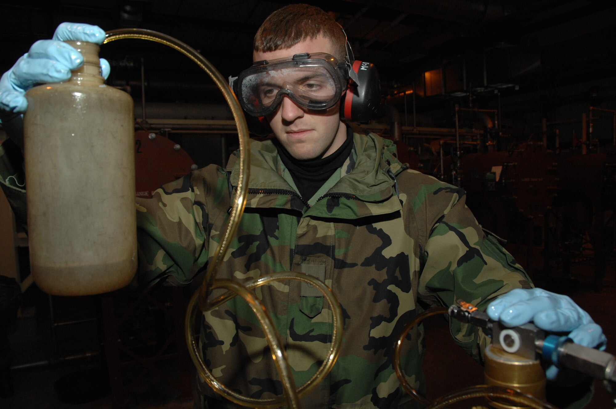 EIELSON AIR FORCE BASE, Alaska -- Airman 1st Class Sean McDonagh, 354th Logistic Readiness Squadron fuels laboratory technician, connects a Gammon Inline Sampler which is used to detect free water in fuel Oct. 24, 2007, at the Oscar Pump House. Making sure the fuel used by the aircraft here at Eielson is always good to go, Airman McDonagh helps assure the process by constantly sampling the fuel lines and also the trucks that distribute it to the aircraft.  (U.S. Air Force photo by Airman 1st Class Christopher Griffin)