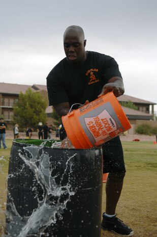 Senior Airman Justin Peacock, a crew chief with the 57th Aircraft Maintenance Squadron participates in the bucket brigade as part of the 2007 Fire Prevention Muster held here, Oct. 12 (U.S. Air Force photo by Airman 1st Class Brian Ybarbo)