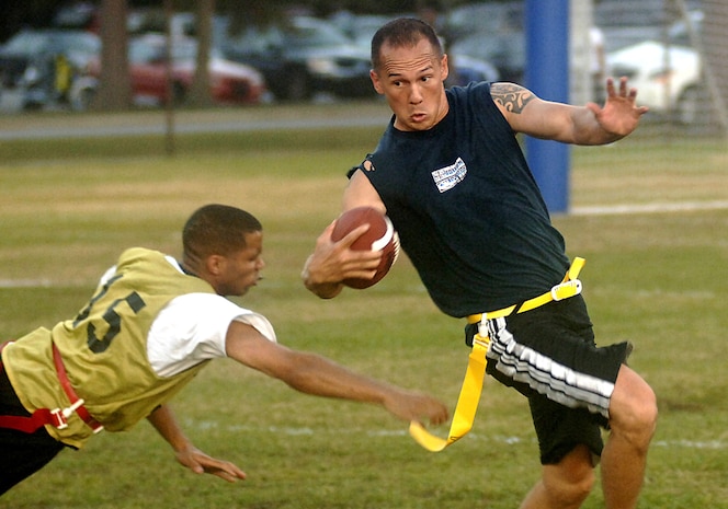 Frederik White, 437 MDG, dives for Carl Kailipaka, 437 AMXS, but misses as Carl runs the ball down the field during an intramural flag football game Tuesday night on base.  (U.S. Air Force photo/Airman 1st Class Nicholas Pilch)