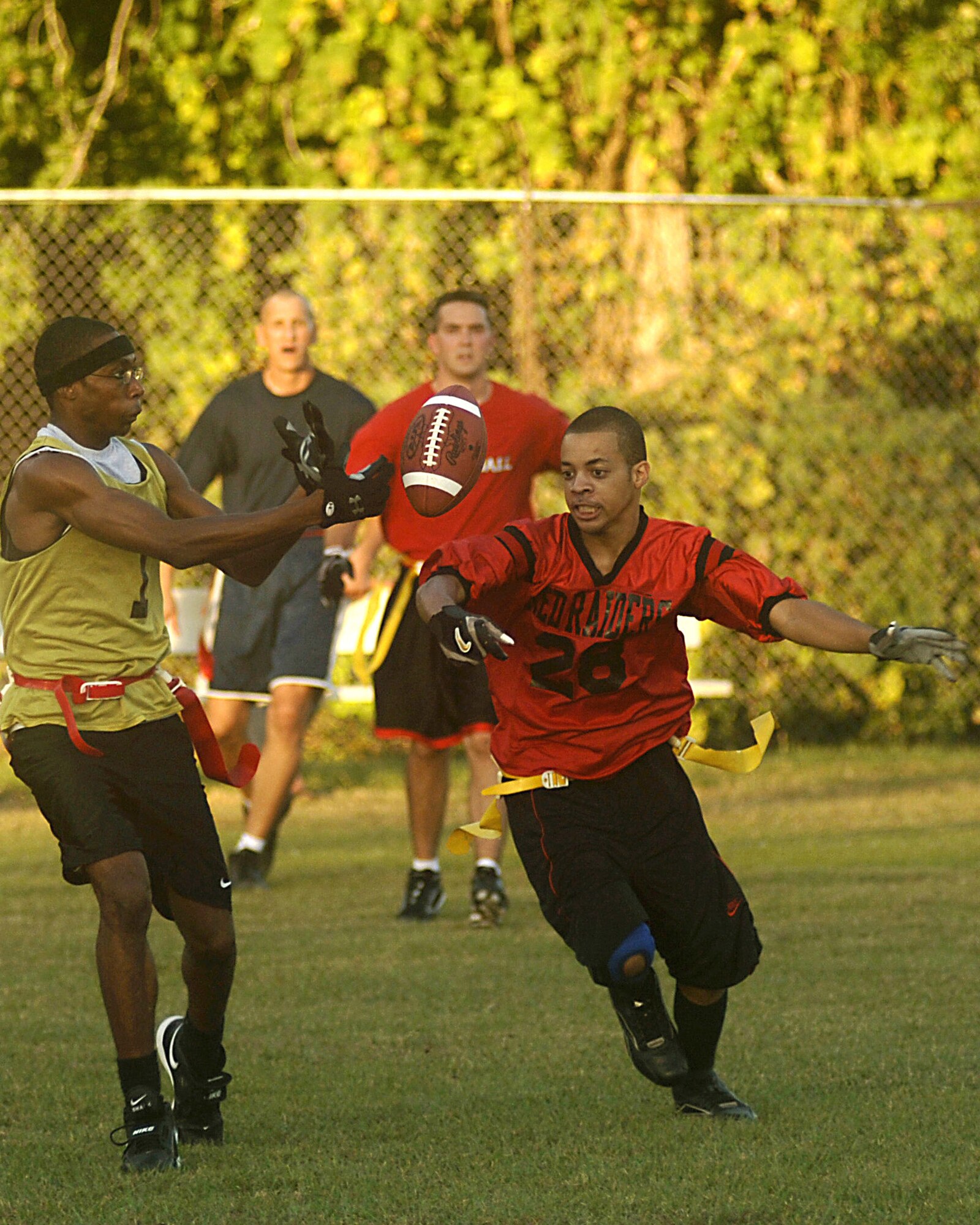 Larico Ellis (left), 437th Medical Group, bobbles the ball while Bradlon Barge, 437th Aircraft Maintenance Squadron, intercepts it during an intramural flag football game Tuesday night on base. Bradlon would have scored a touchdown if his team had not committed a holding foul. (U.S. Air Force Photo/Airman 1st Class Nicholas Pilch)