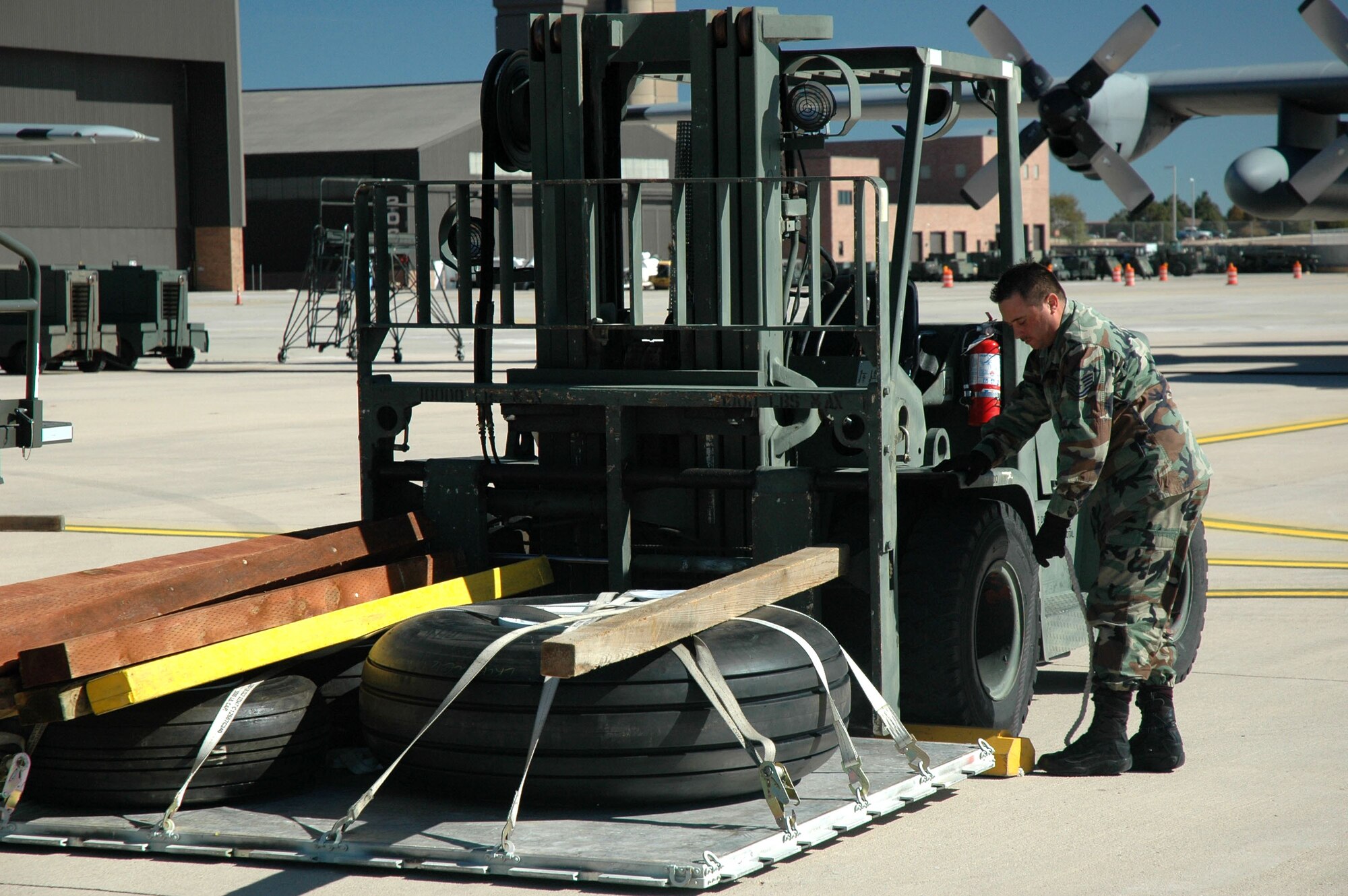 Tech. Sgt. Ramon Valdiviex prepares aircraft parts and equipment to be loaded onto an Air Force Reserve C-130 bound for southern California Oct. 23 to lay lines of containment to help in the fight against the wildfires burning there. Two of the Modular Airborne Firefighting Systems departed Peterson Air Force Base, Colo., earlier that day. Sergeant Valdiviez was loads the final cargo aircraft with supplies needed to sustain the aerial firefighting mission as long as needed. Sergeant Veldiviex is with the 39th Aerial Port Squadron.(U.S. Air Force photo/Maj. James R. Wilson) 